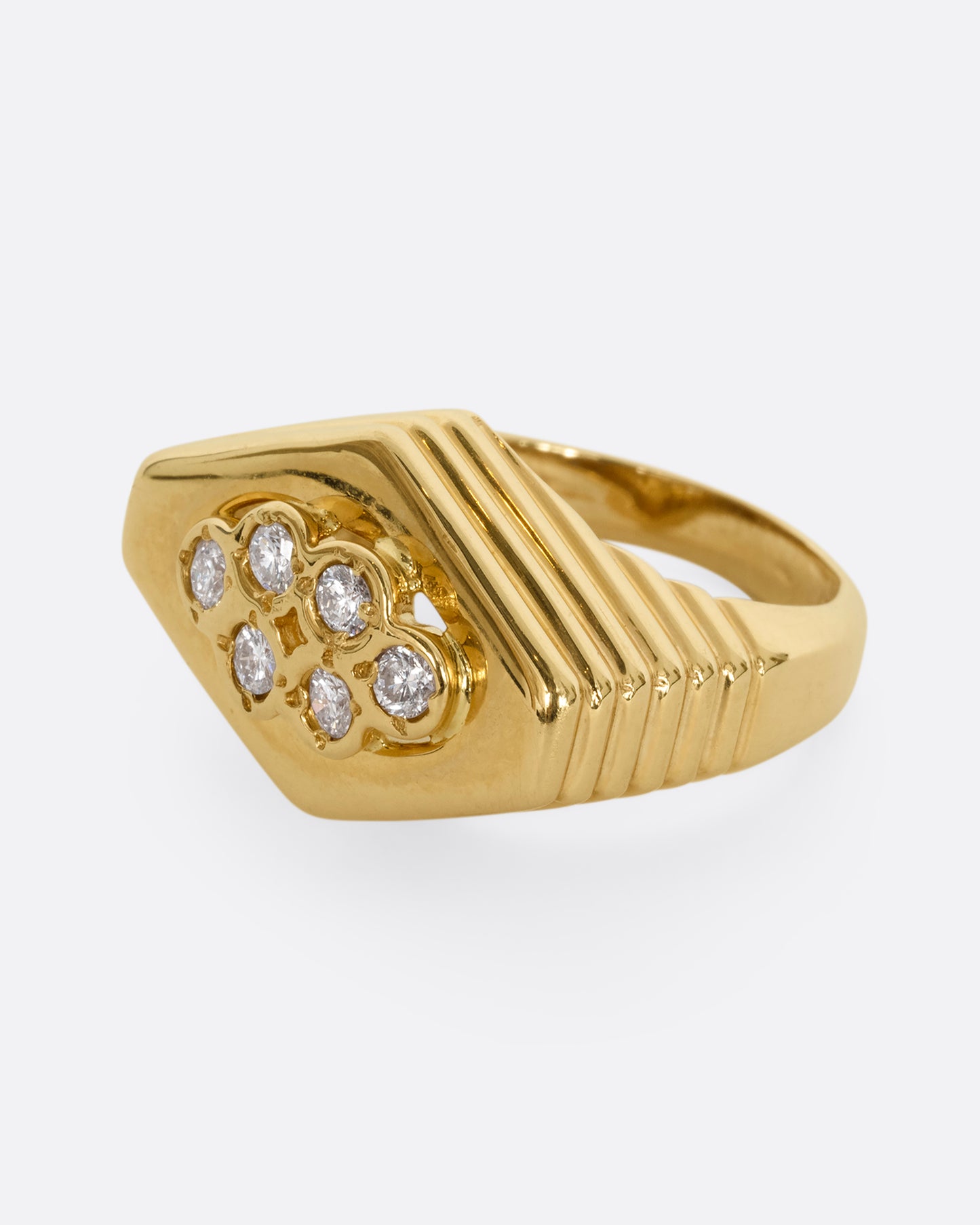 A yellow gold squared diamond shaped ring with a ribbed base and six round diamonds on the face. Shown from the side.