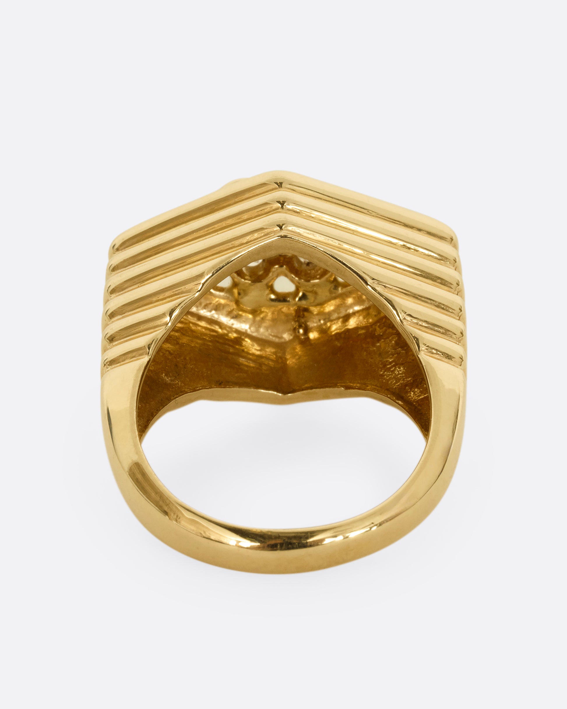 A yellow gold squared diamond shaped ring with a ribbed base and six round diamonds on the face. Shown from the back.