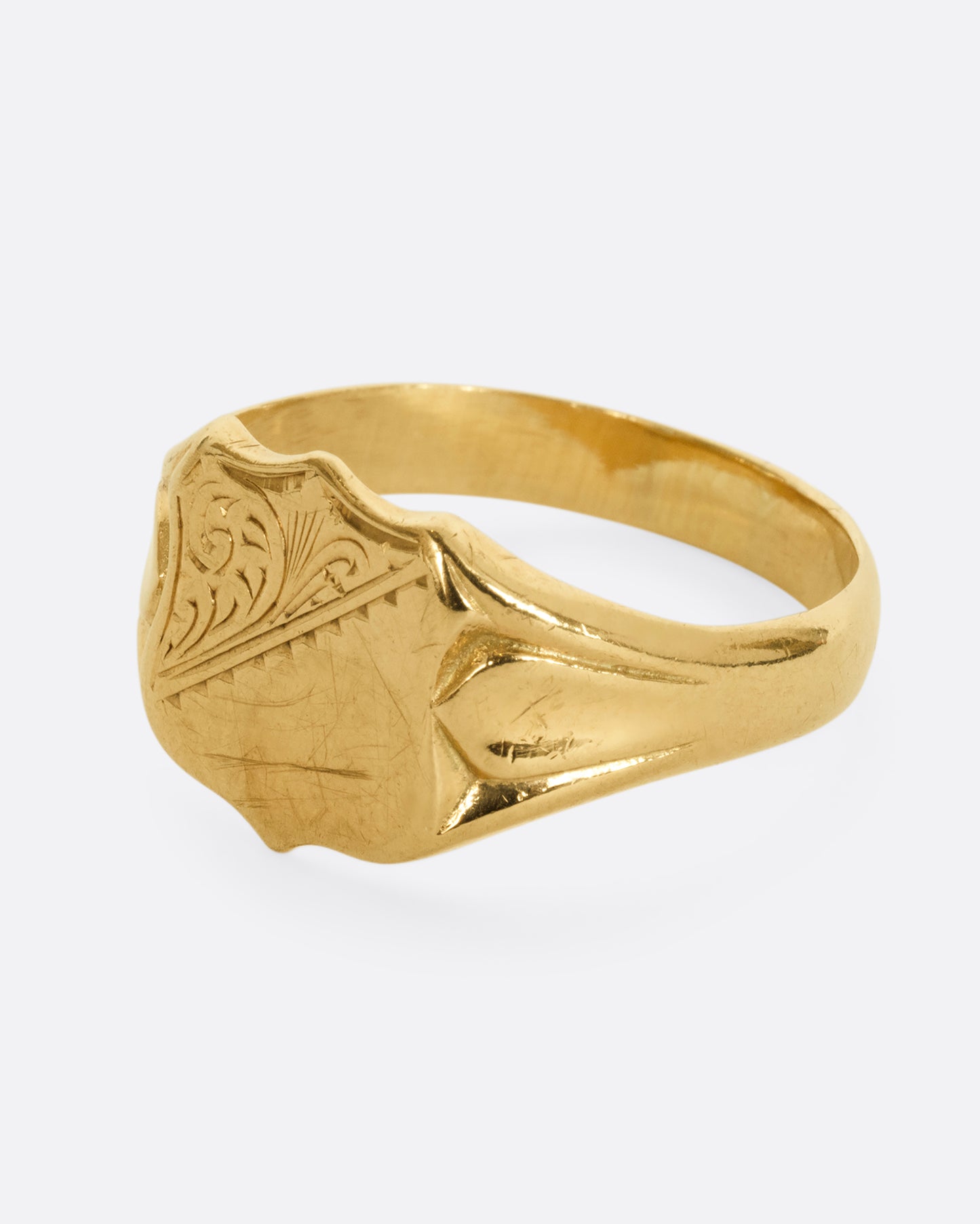 A yellow gold shield signet ring. Shown from the side.