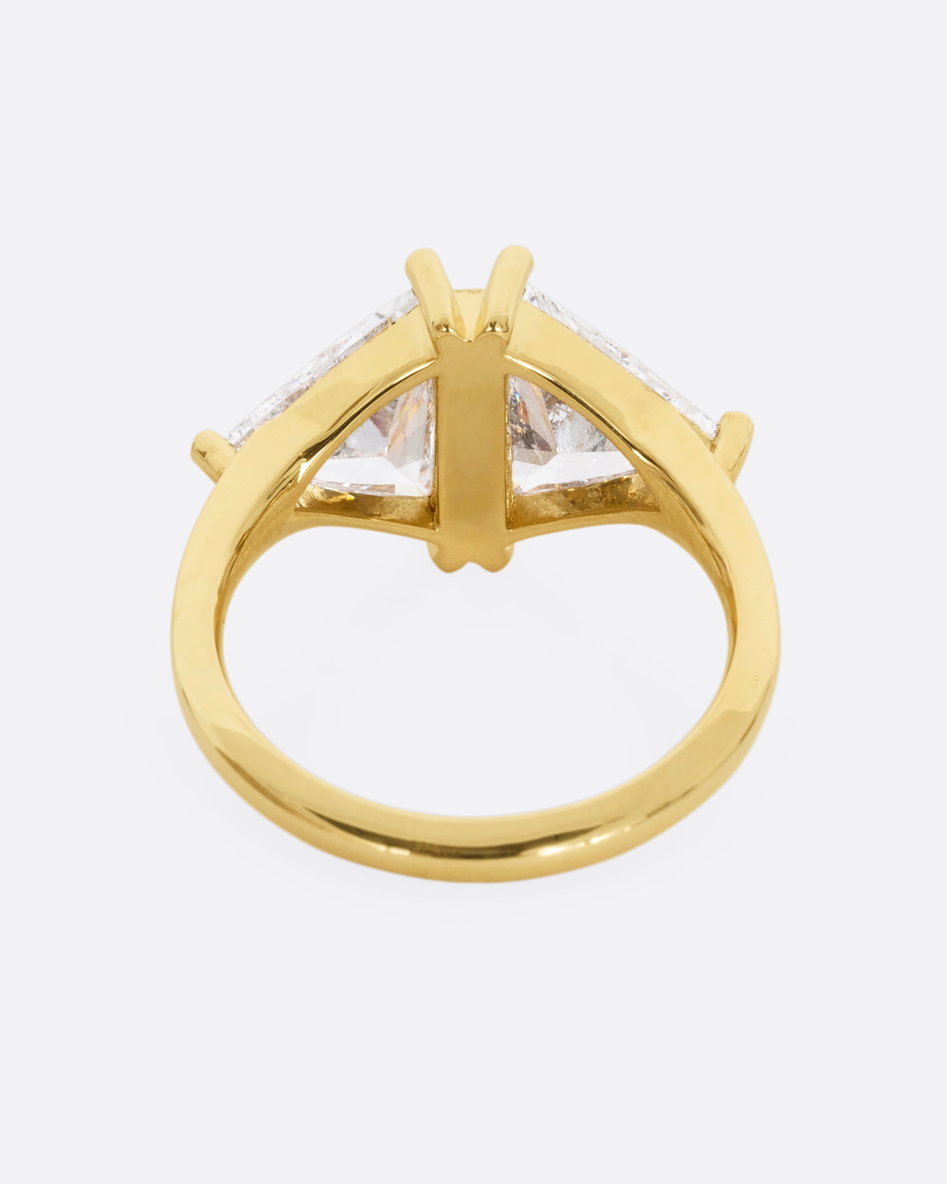 A yellow gold ring with two salt and pepper trillion cut diamonds and diamond accents. Shown from the back.