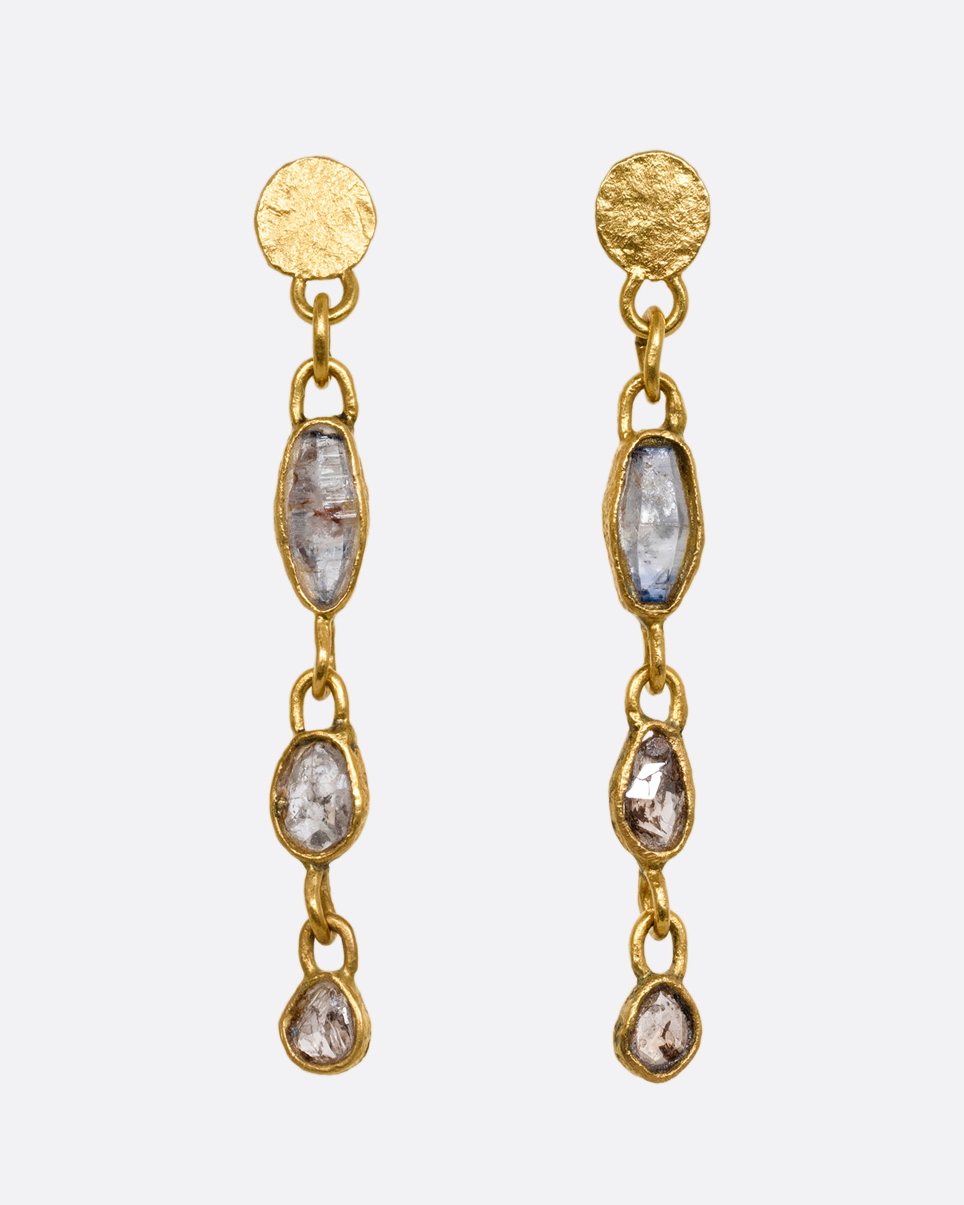 Yellow gold wrapped sapphire and  diamond earrings falling  from hammered gold discs. Shown from the front.