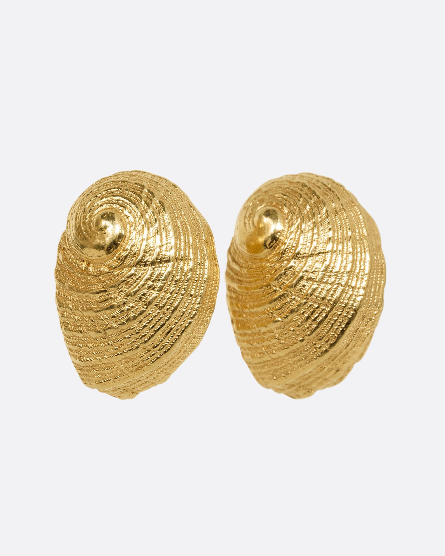 A pair of yellow gold earrings in the shape of a shell. Shown from the side.