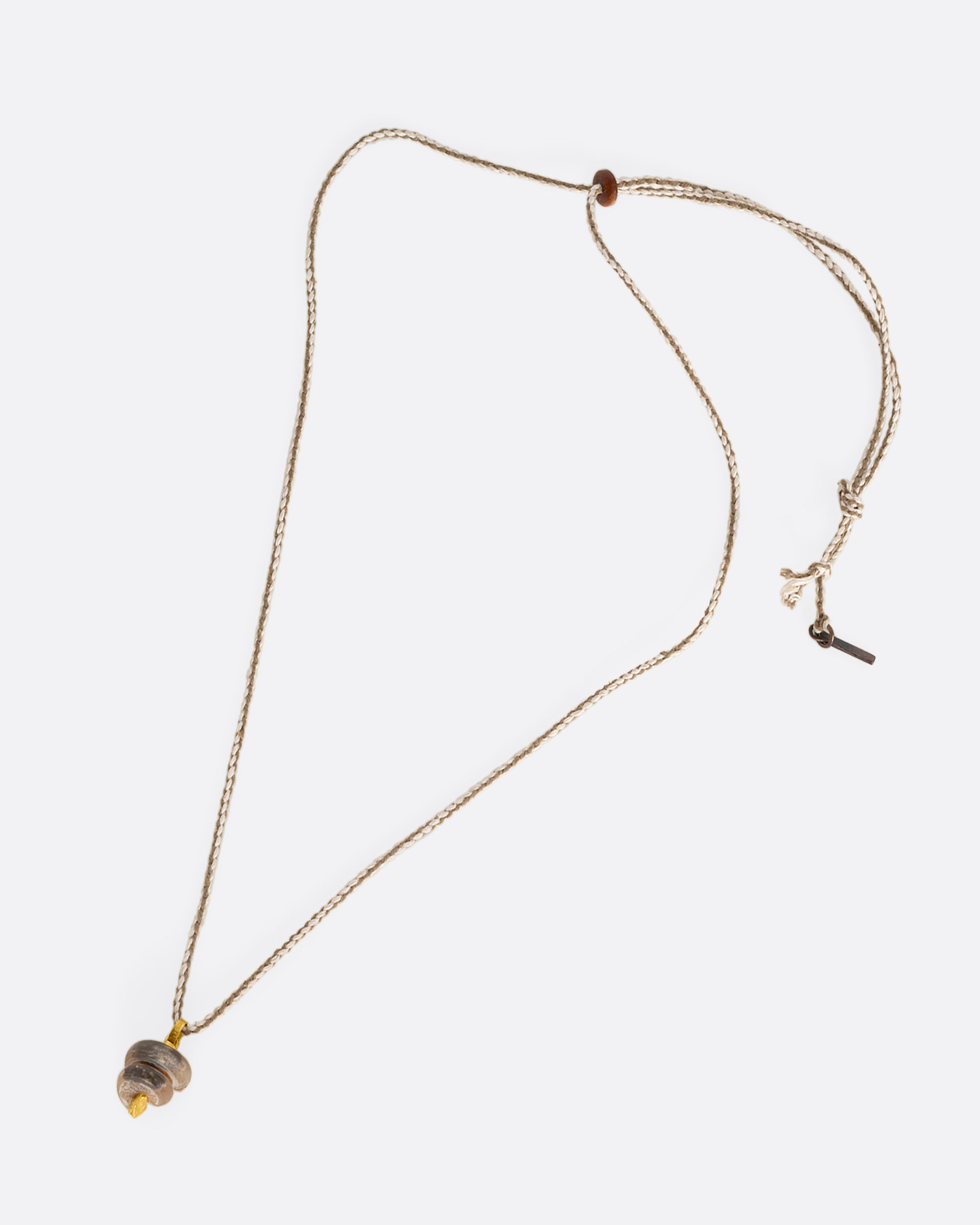 A high karat yellow gold necklace with an agate twist on a cord. Shown laying flat.