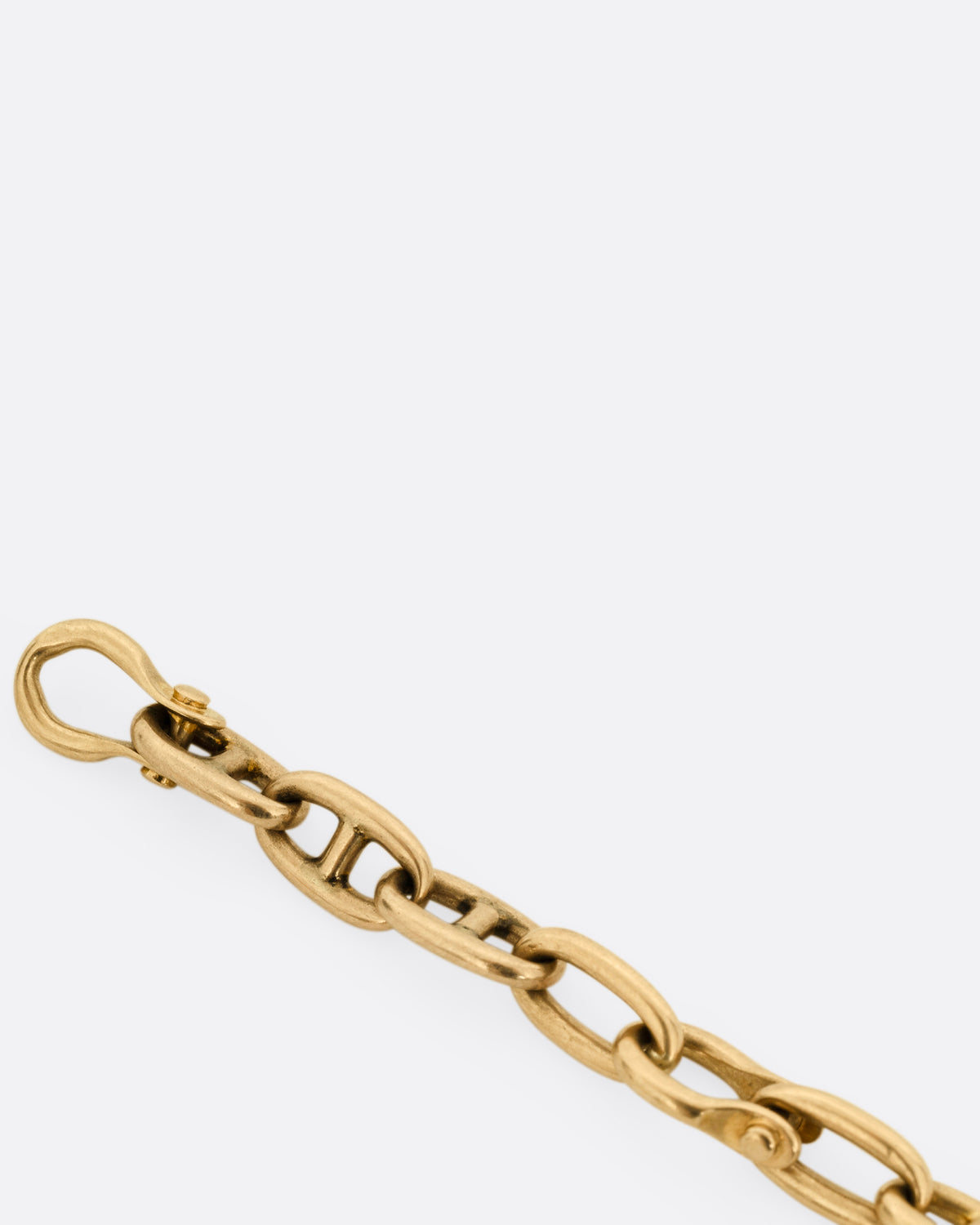 A close up of a rose gold mariner watch chain necklace.
