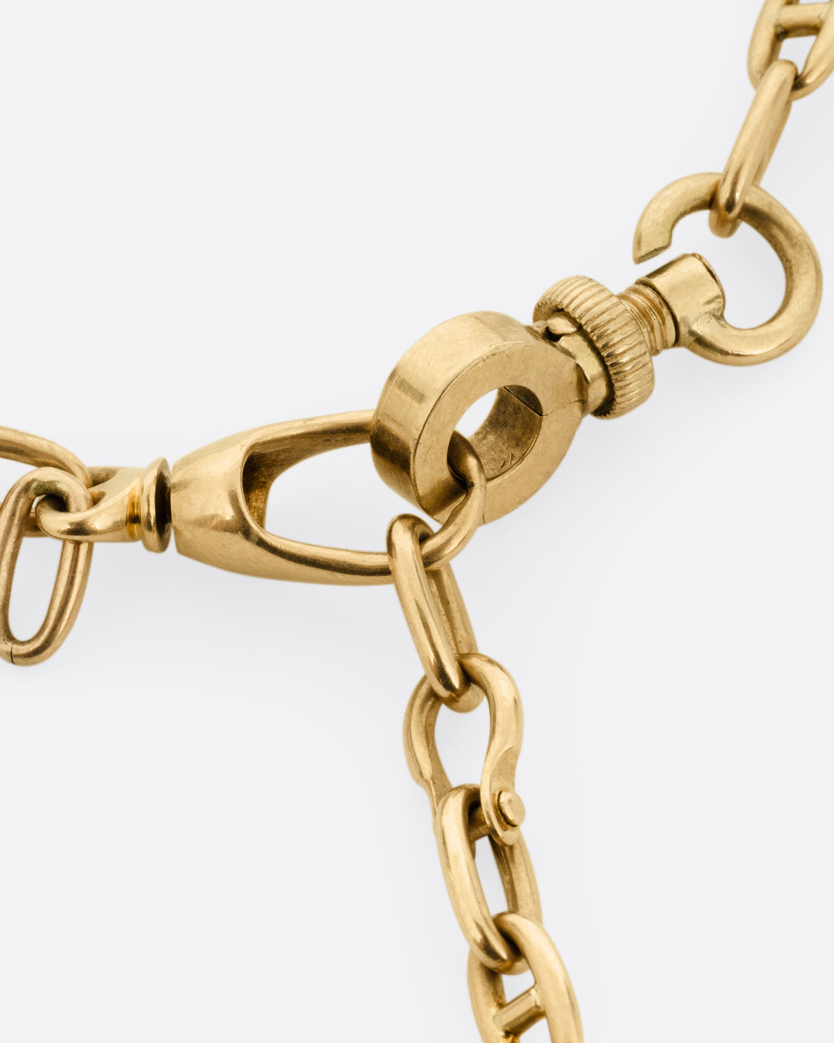 A close up of the clasp of a rose gold mariner watch chain necklace.