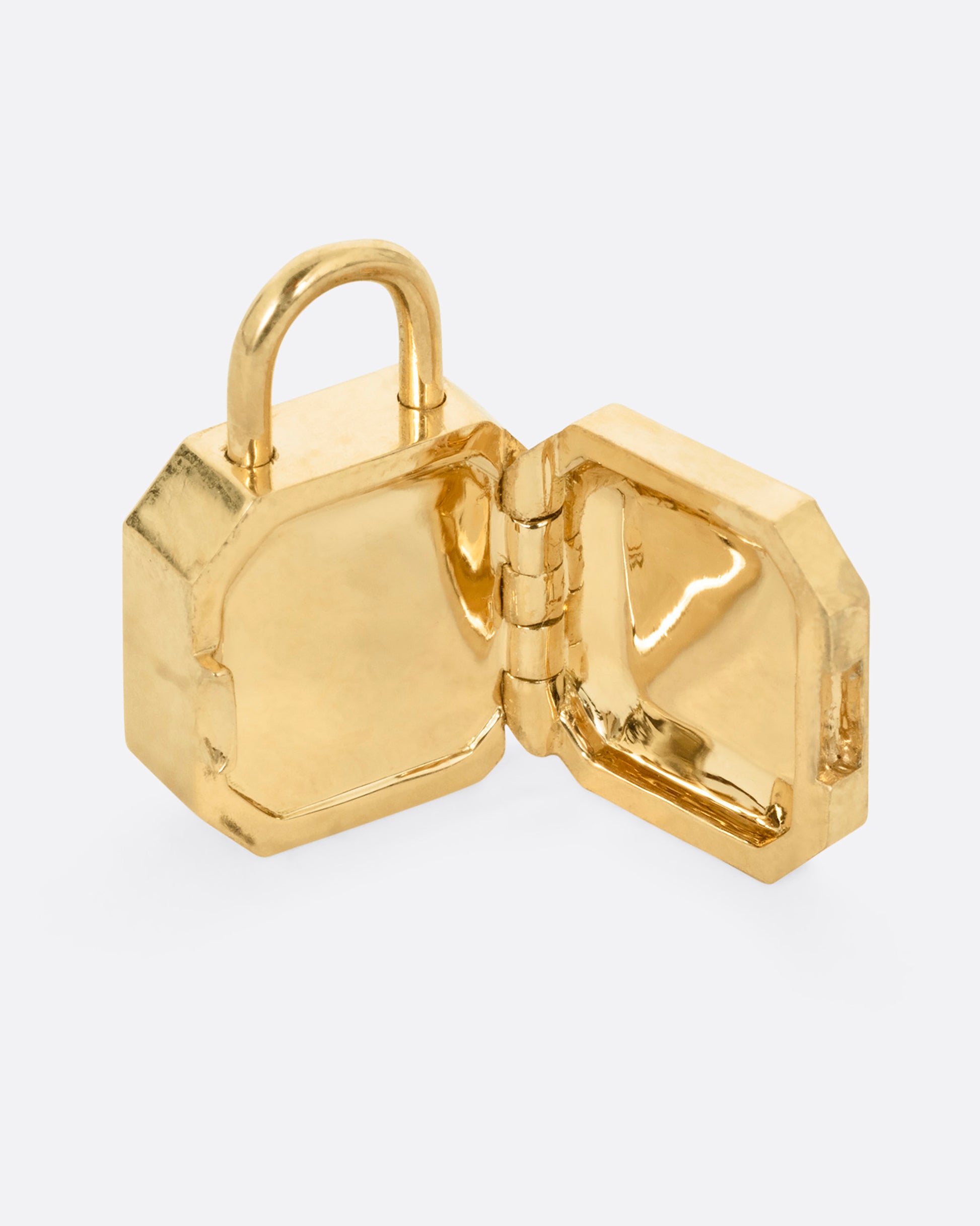 A yellow gold padlock shaped locket with a champagne diamond, shown open.