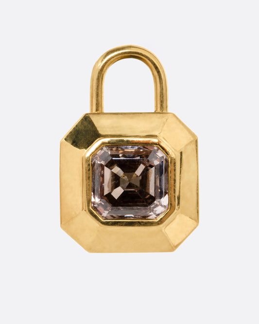 A yellow gold padlock shaped locket with a champagne diamond, shown from the front.