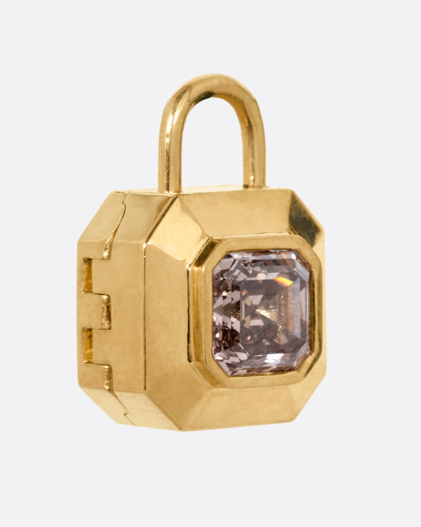 A yellow gold padlock shaped locket with a champagne diamond, shown from the side.