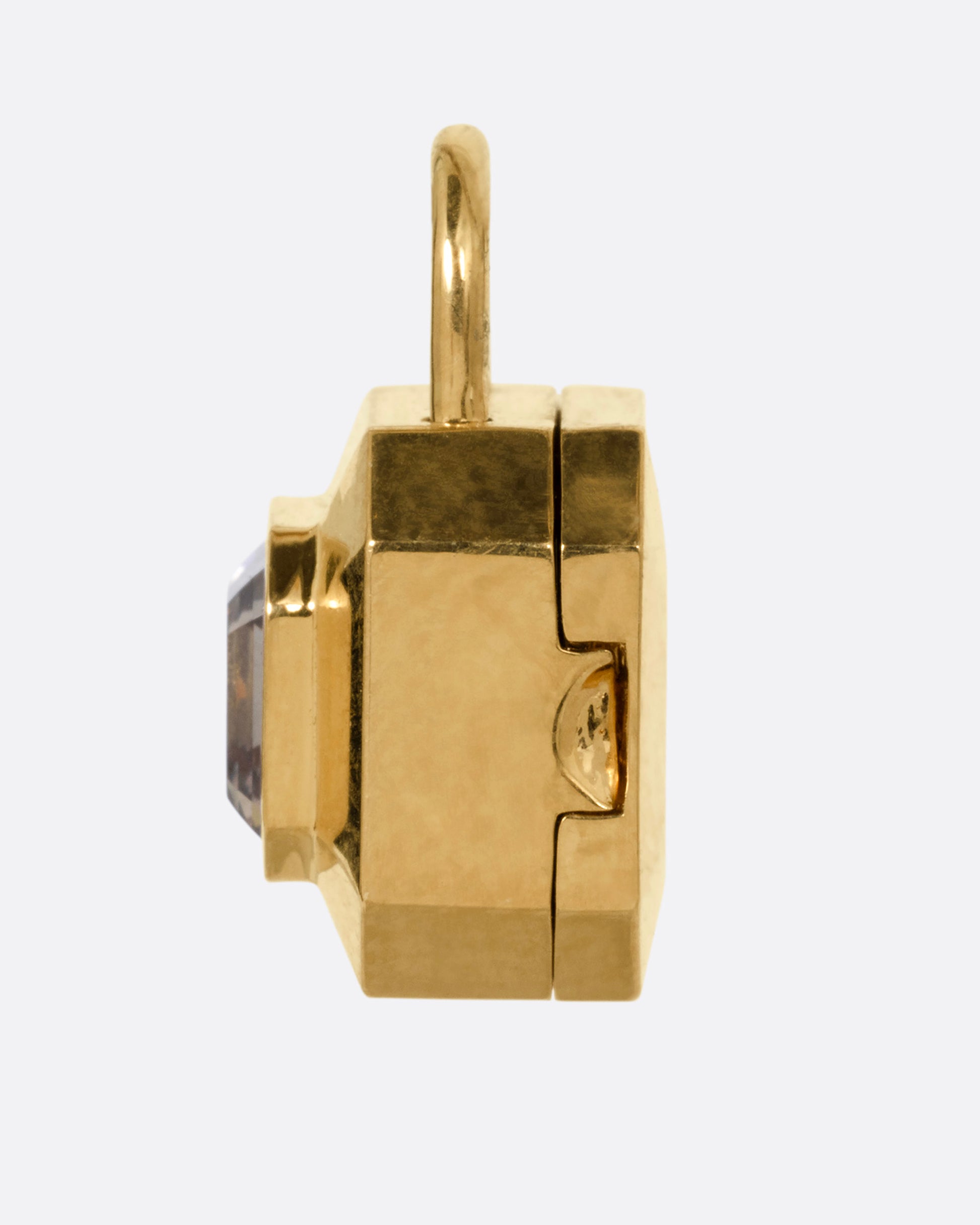 A yellow gold padlock shaped locket with a champagne diamond, shown from the side.