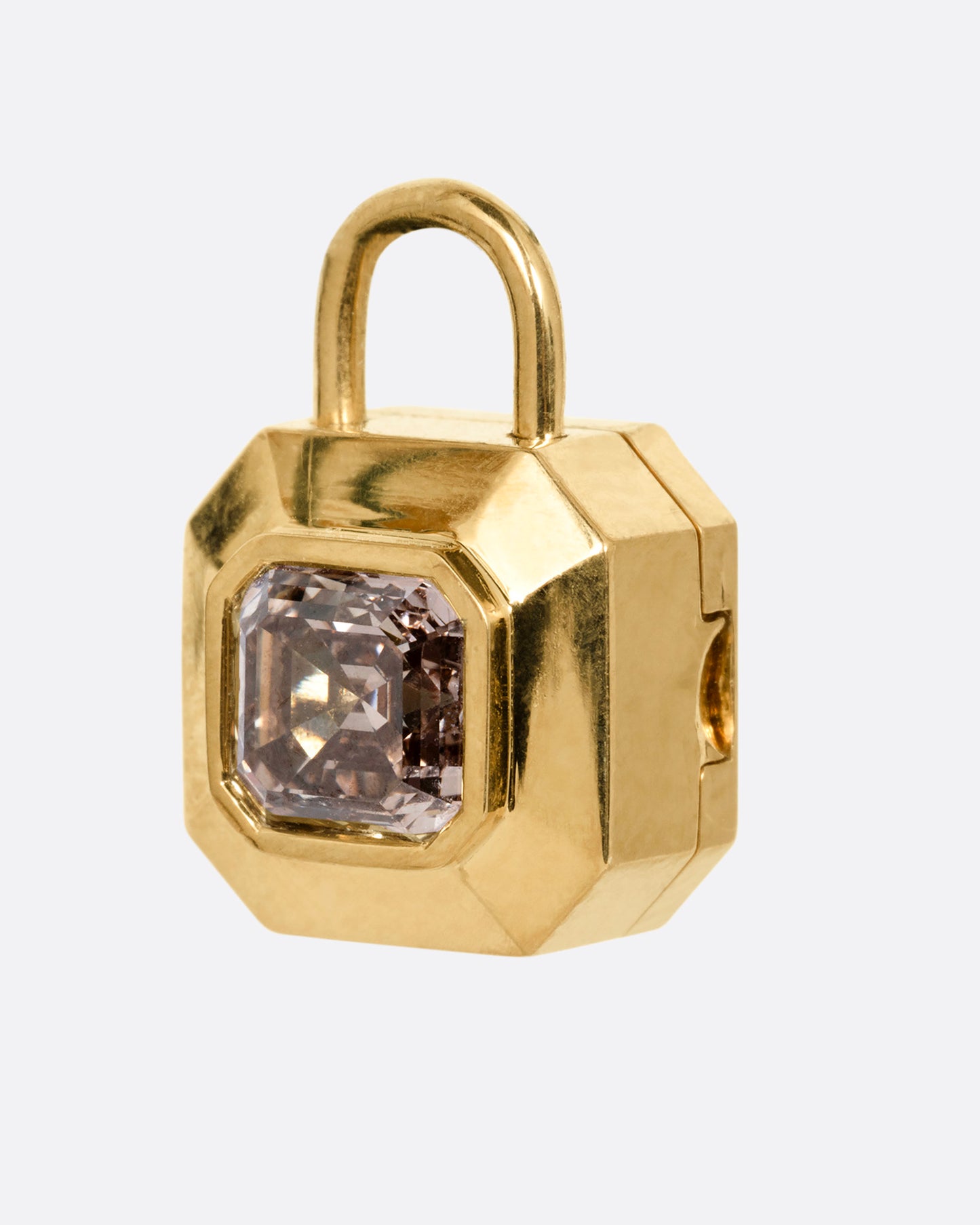 A yellow gold padlock shaped locket with a champagne diamond, shown from the side.