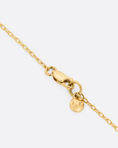 A close up of the clasp on a yellow gold necklace.