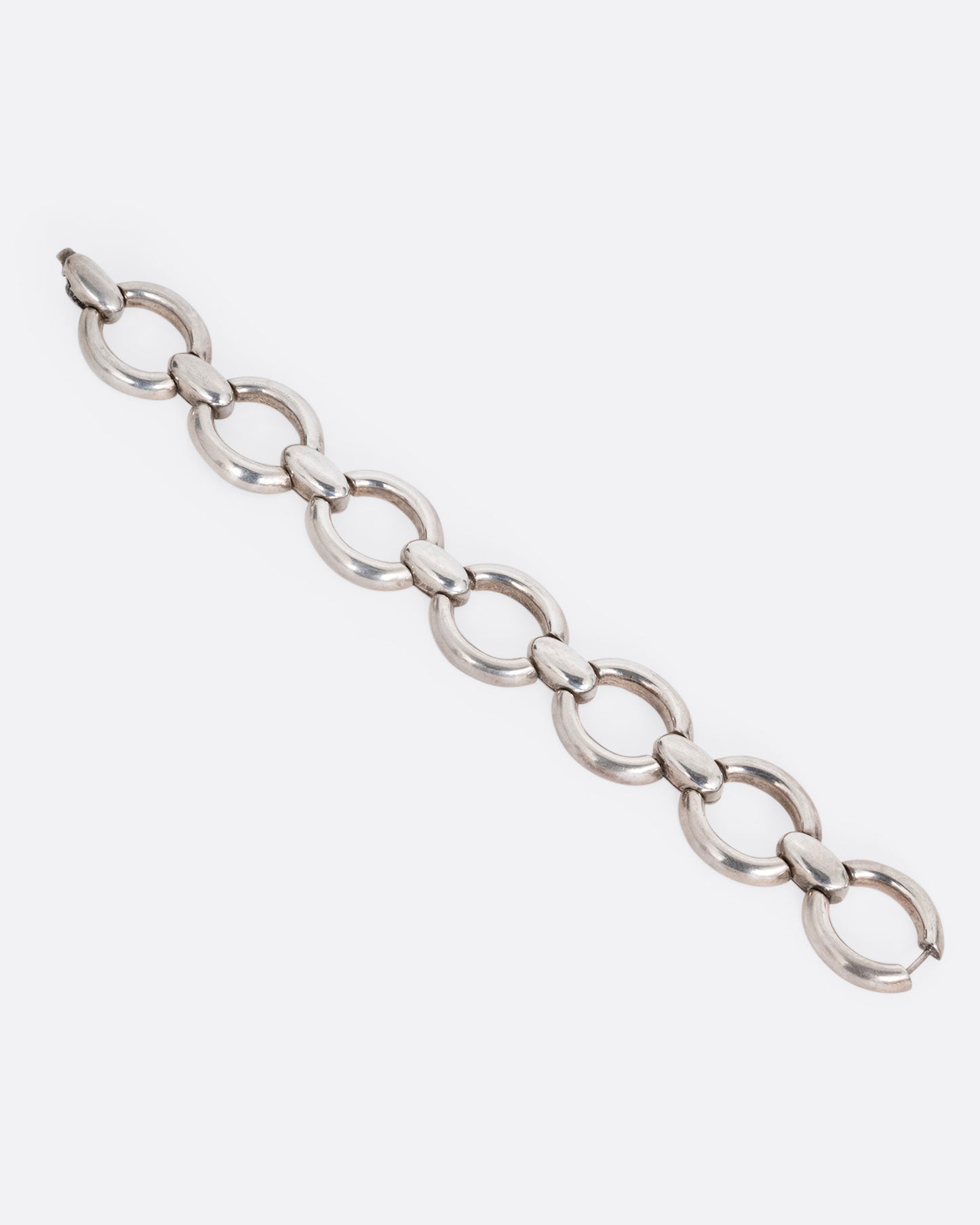 A silver bracelet with broad open oval links, shown from the front.