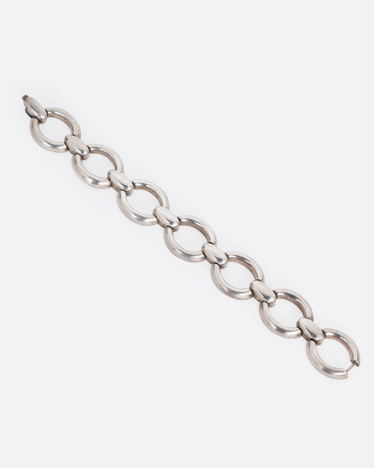 A silver bracelet with broad open oval links, shown from the front.
