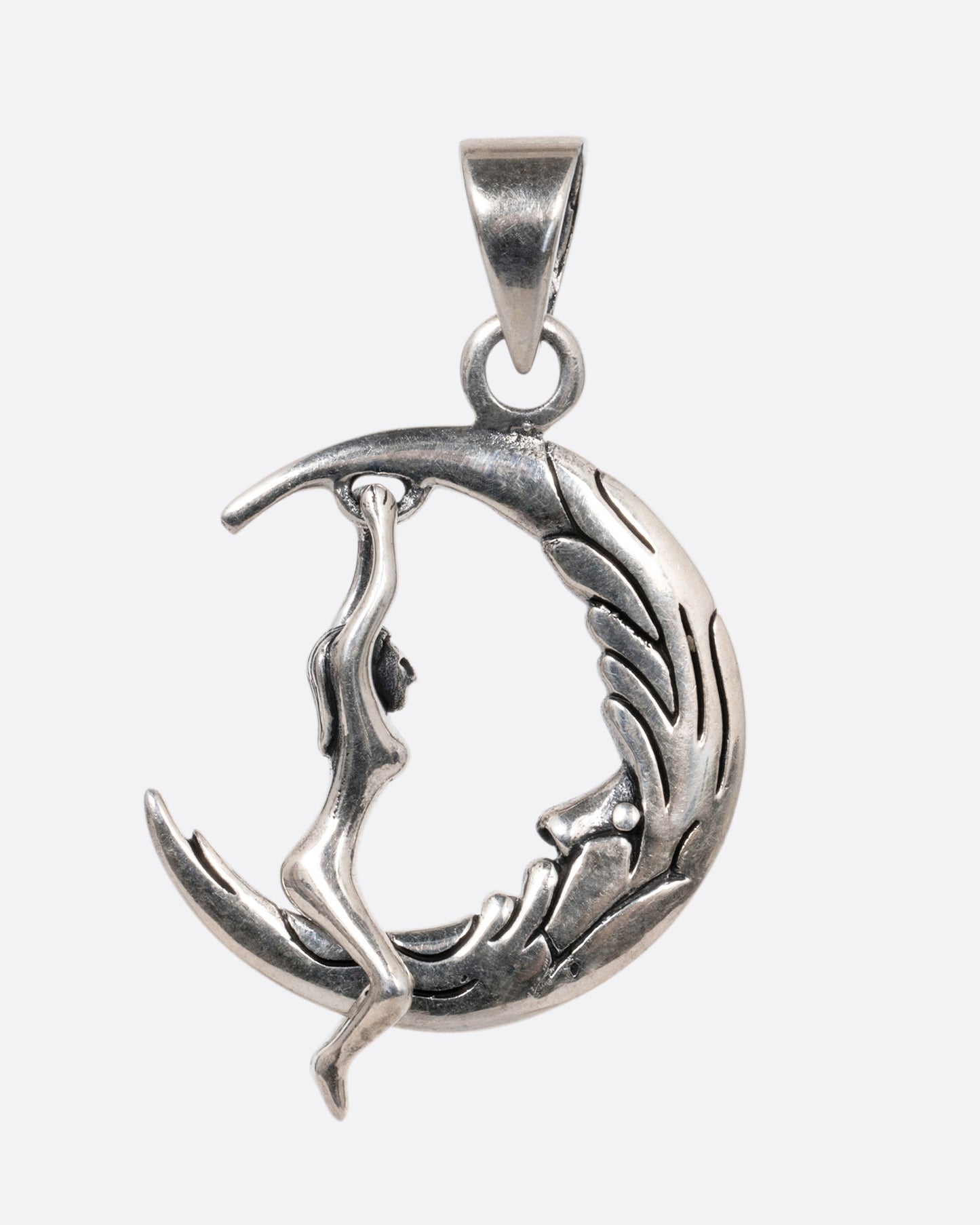 A silver pendant with a woman grasping a craggy crescent moon, shown from the front.