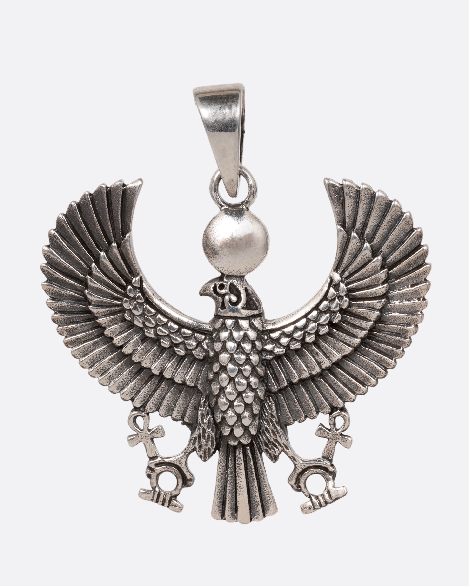 A silver pendant depicting the ancient Egyptian god, Horus, in falcon form, shown from the front. 