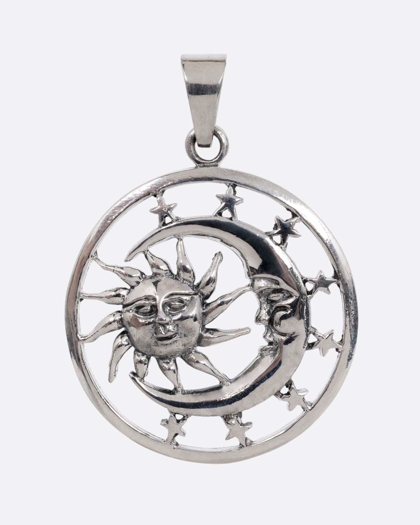 A circular silver pendant with the sun, moon, and stars, shown from the front.