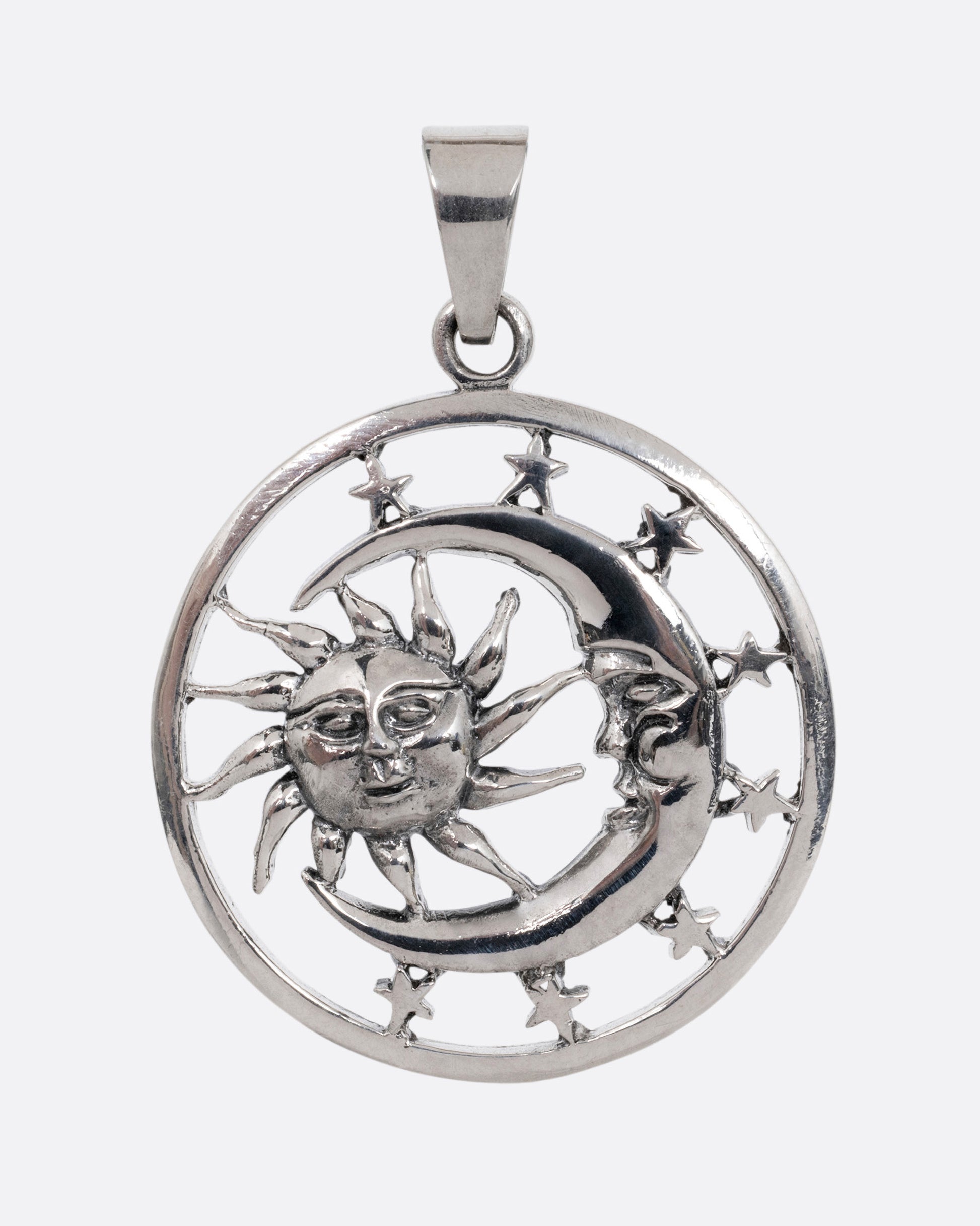 A circular silver pendant with the sun, moon, and stars, shown from the front.