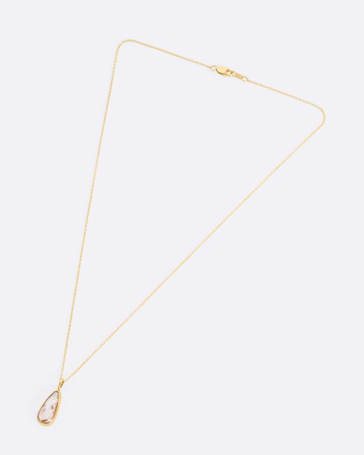 A yellow gold cable chain necklace with a teardrop shaped Australian opal pendant. Shown from the front.