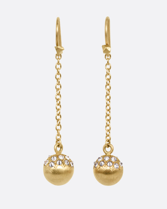 A pair of yellow gold drop earrings with lengths of gold cable chain ending in brushed gold spheres with reverse set grey diamonds. Shown from the front.