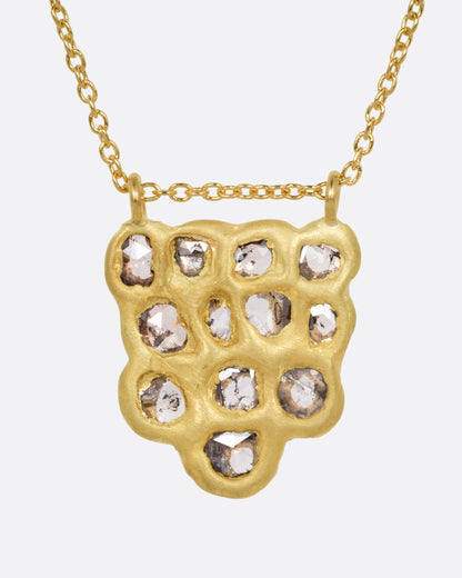 A yellow gold pendant necklace with a cluster of rose cut diamonds, shown from the front.