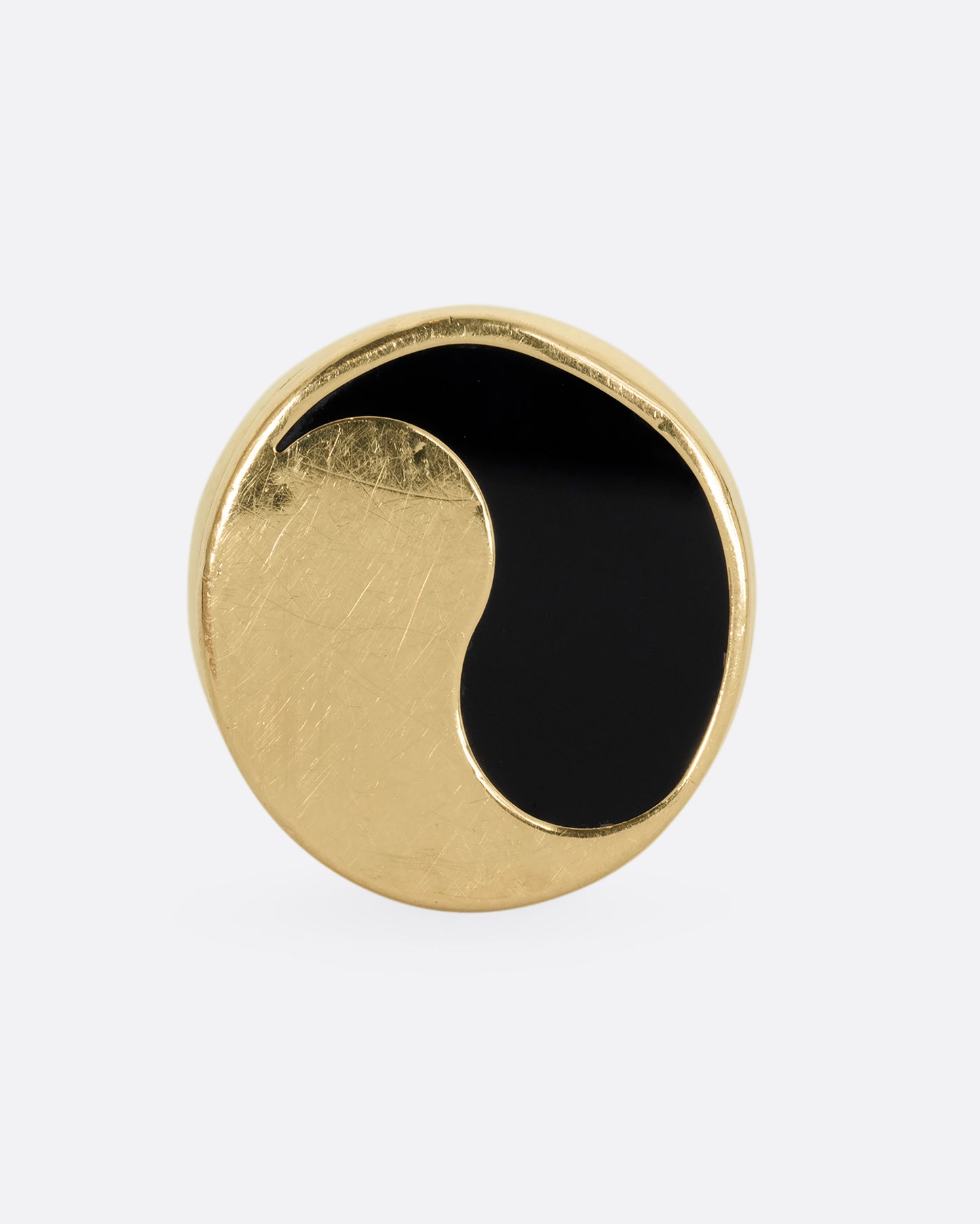 A yellow gold ring with a yin yang symbol made of onyx. Shown from the front.