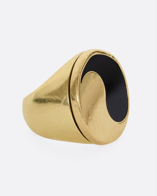 A yellow gold ring with a yin yang symbol made of onyx. Show from the side.