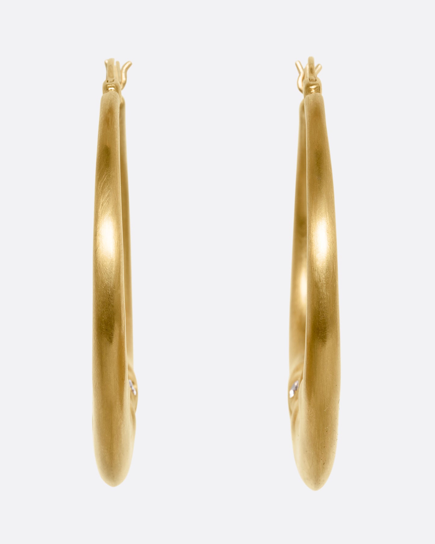 yellow gold crescent shaped oop earring with diamond eyes shown from the back