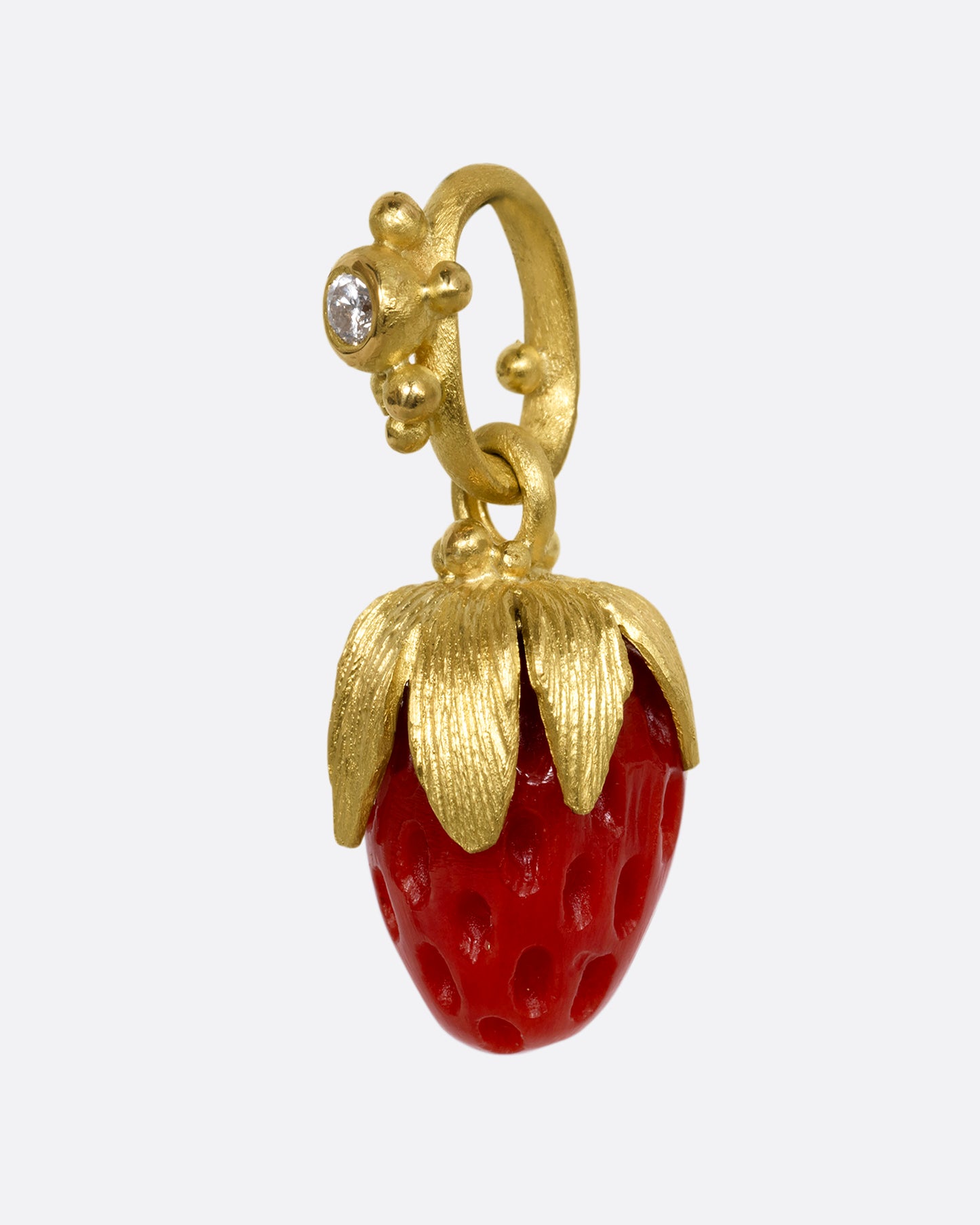 yellow gold charm with diamond and strawberry shaped coral shown from the side