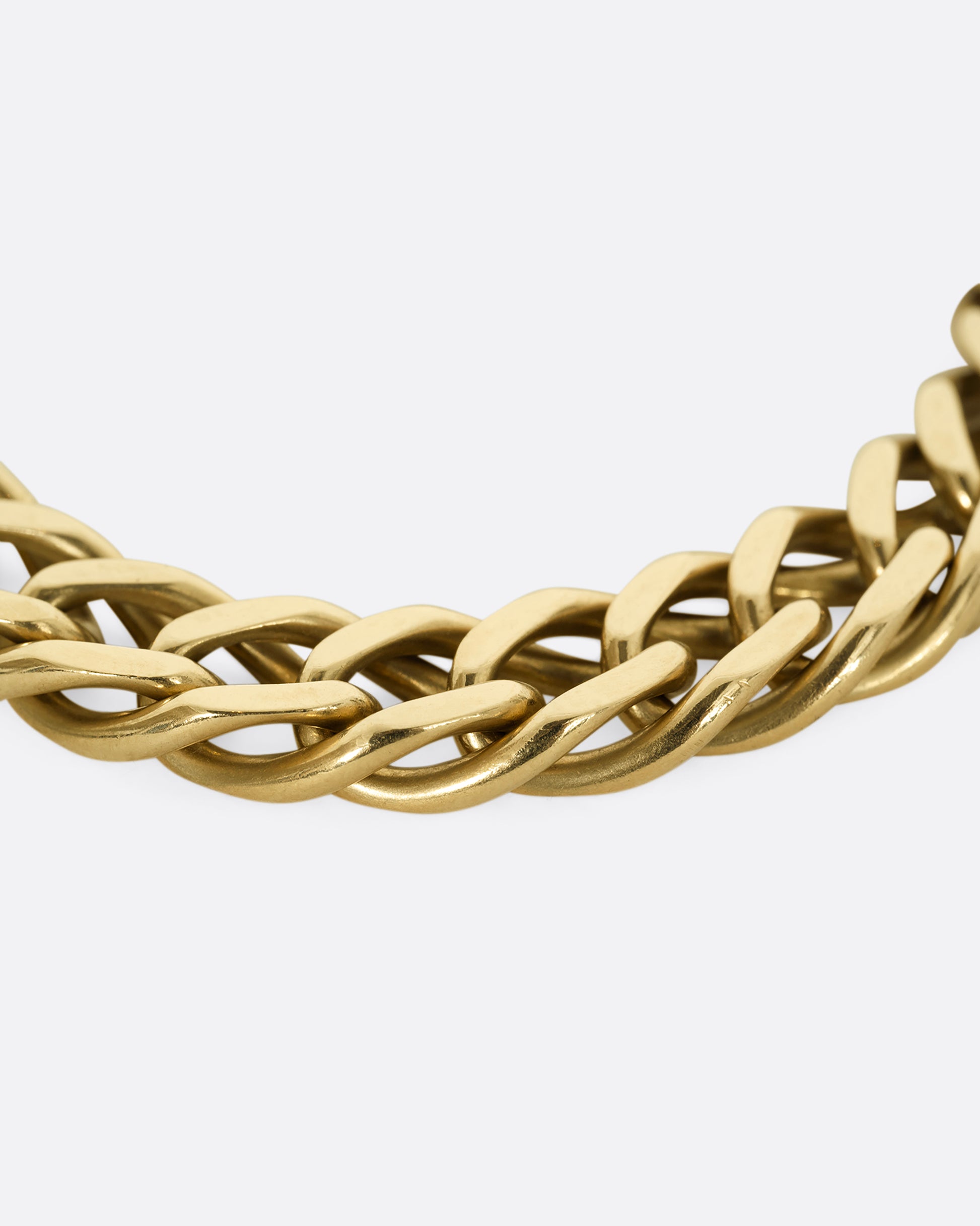 A yellow gold double curb chain bracelet. Close up of the links.