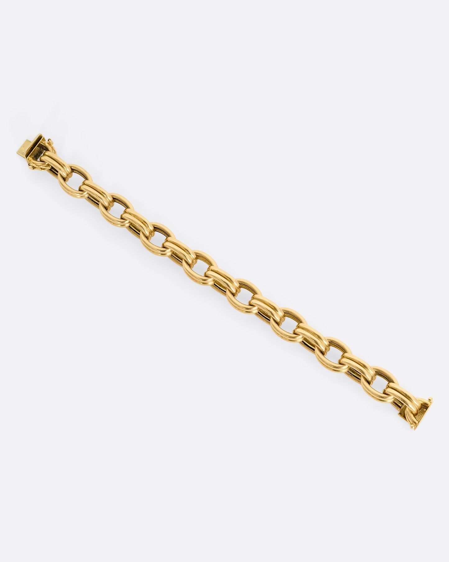 A yellow gold bracelet with double oval links. Shown laying flat.