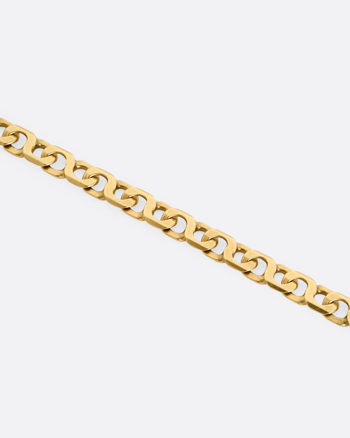 A yellow gold bracelet with infinity links Shown laying flat, close up.