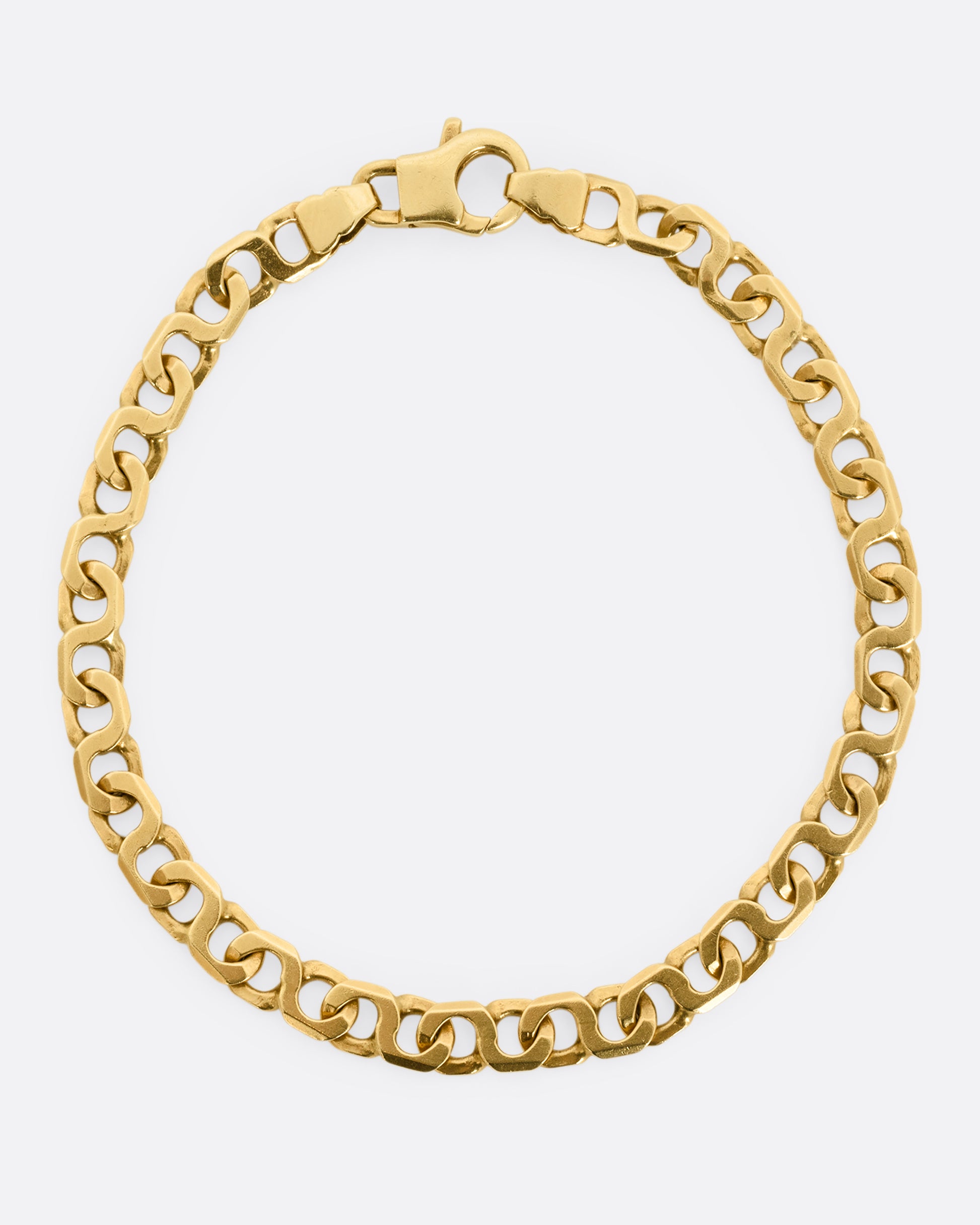A yellow gold bracelet with infinity links Shown from above.