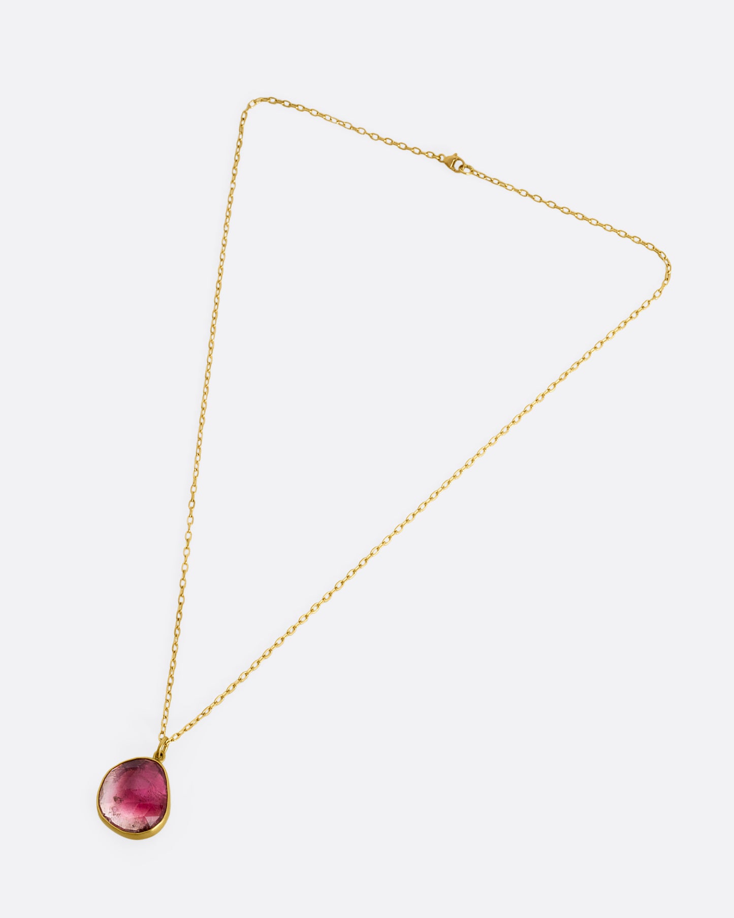 yellow gold necklace with an ombre pink tourmaline shown from afar