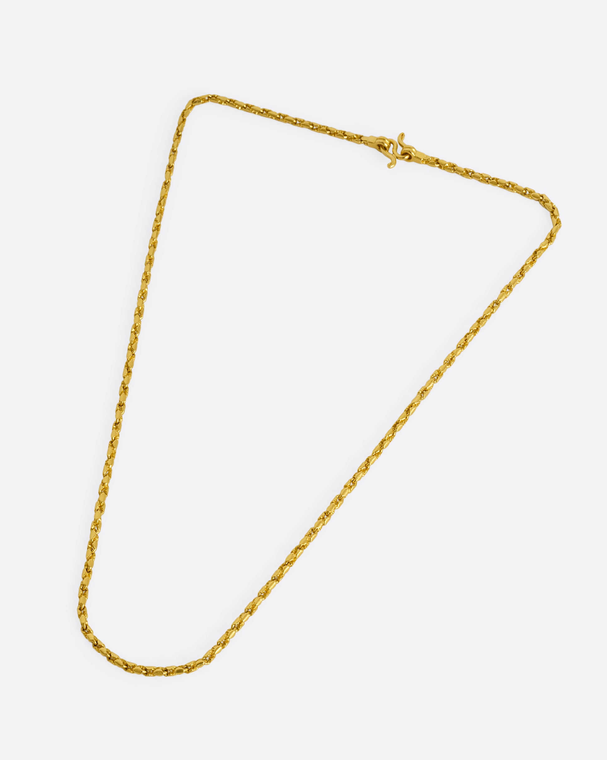 A high karat yellow gold Thai bhat chain. Shown laying flat from above.