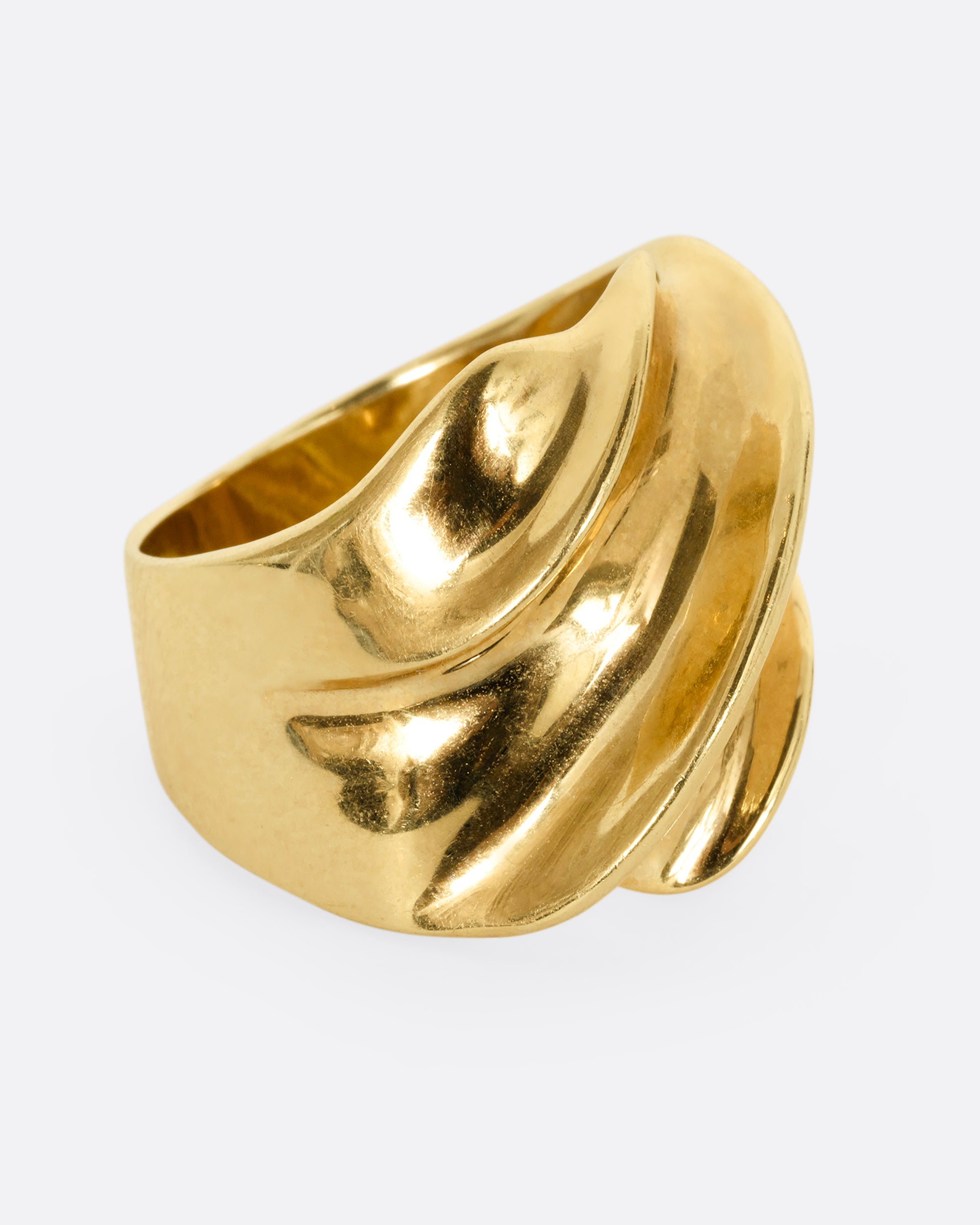 A chunky yellow gold wave ring. Shown from the side.