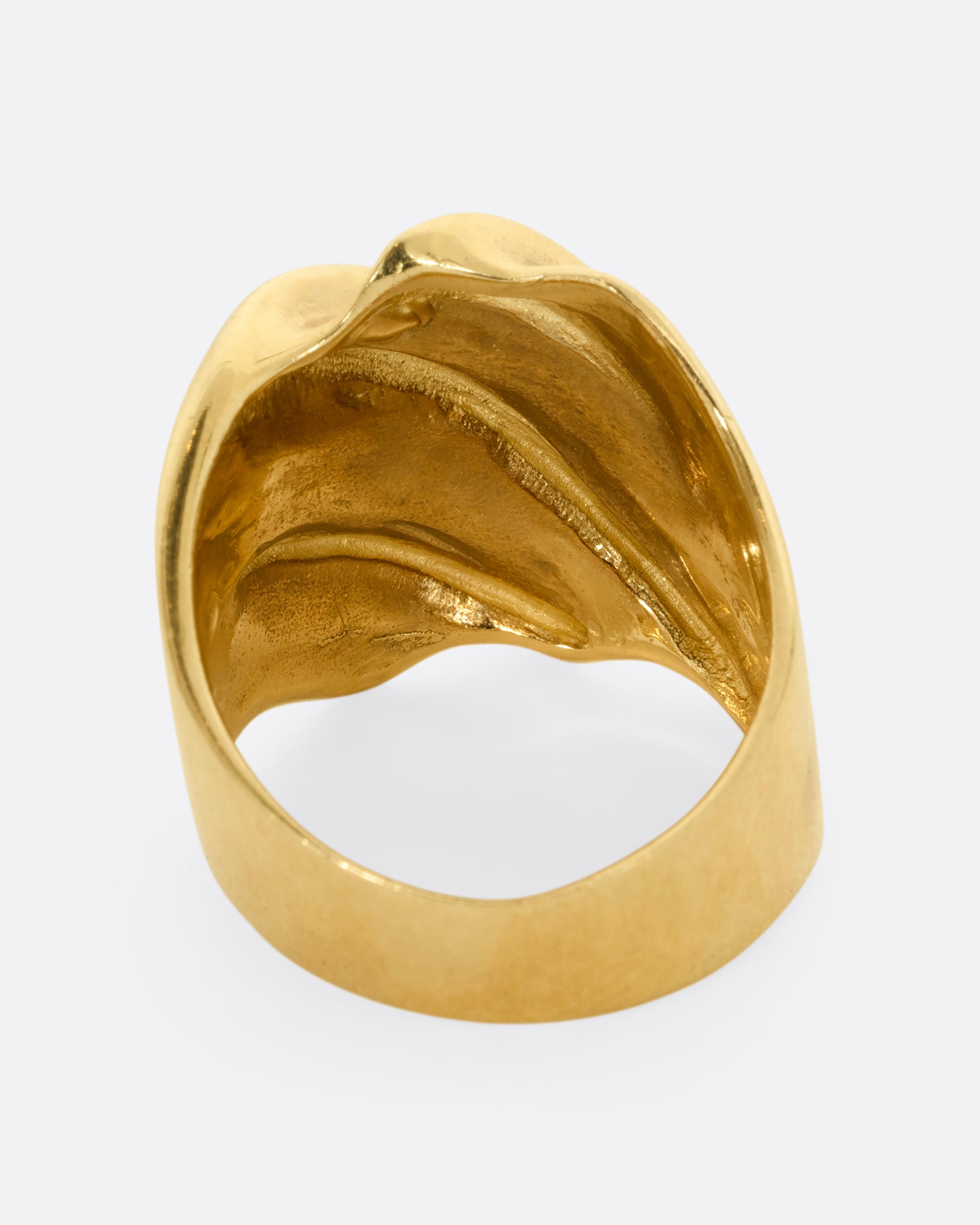 A chunky yellow gold wave ring. Shown from the back.