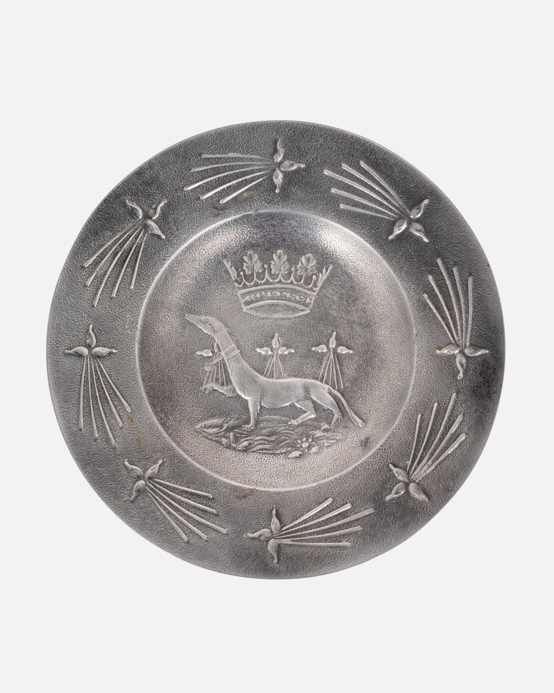 A round pester dish with a dog and crown emblem, shown from the top.