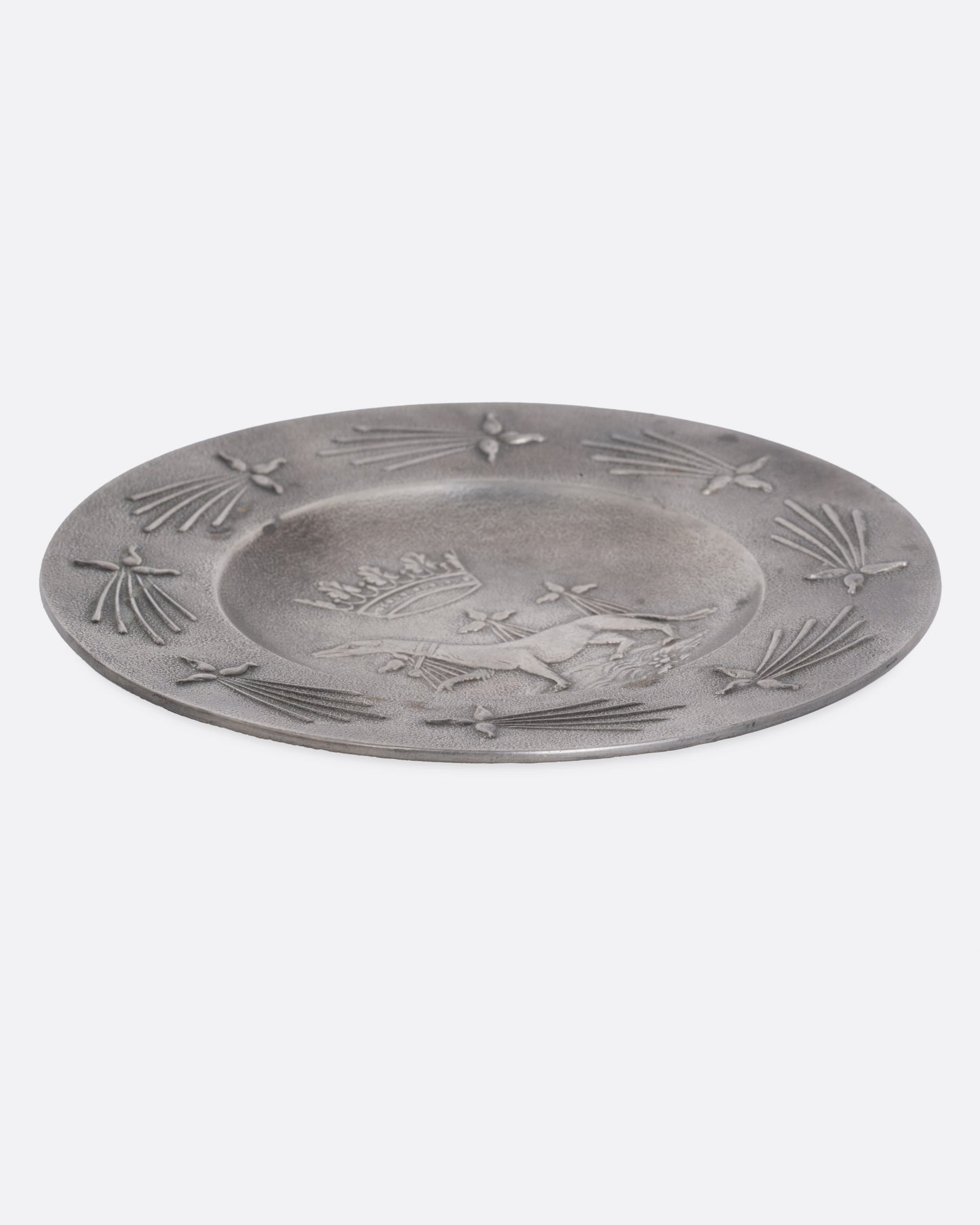 A round pester dish with a dog and crown emblem, shown from the side.