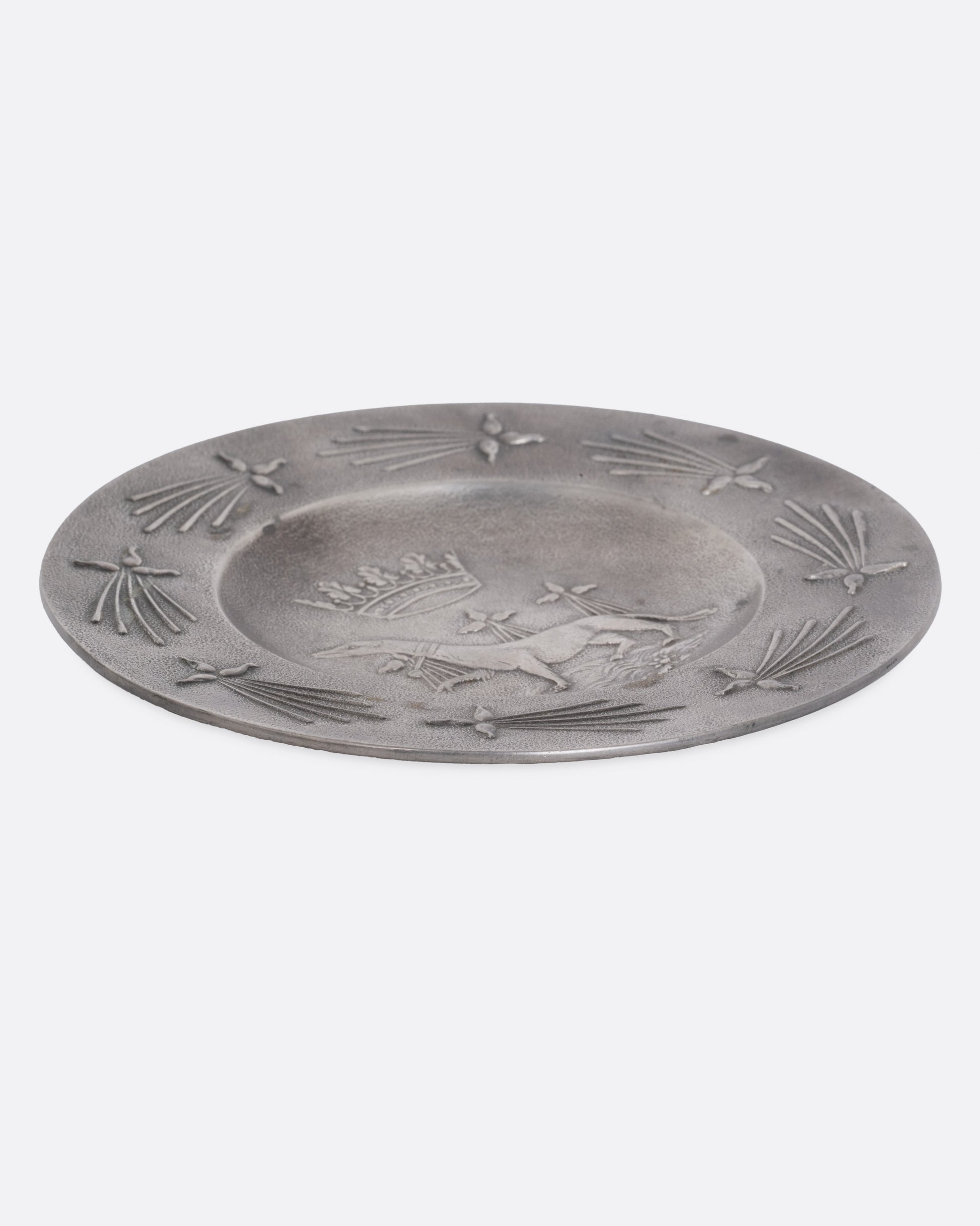 A round pester dish with a dog and crown emblem, shown from the side.