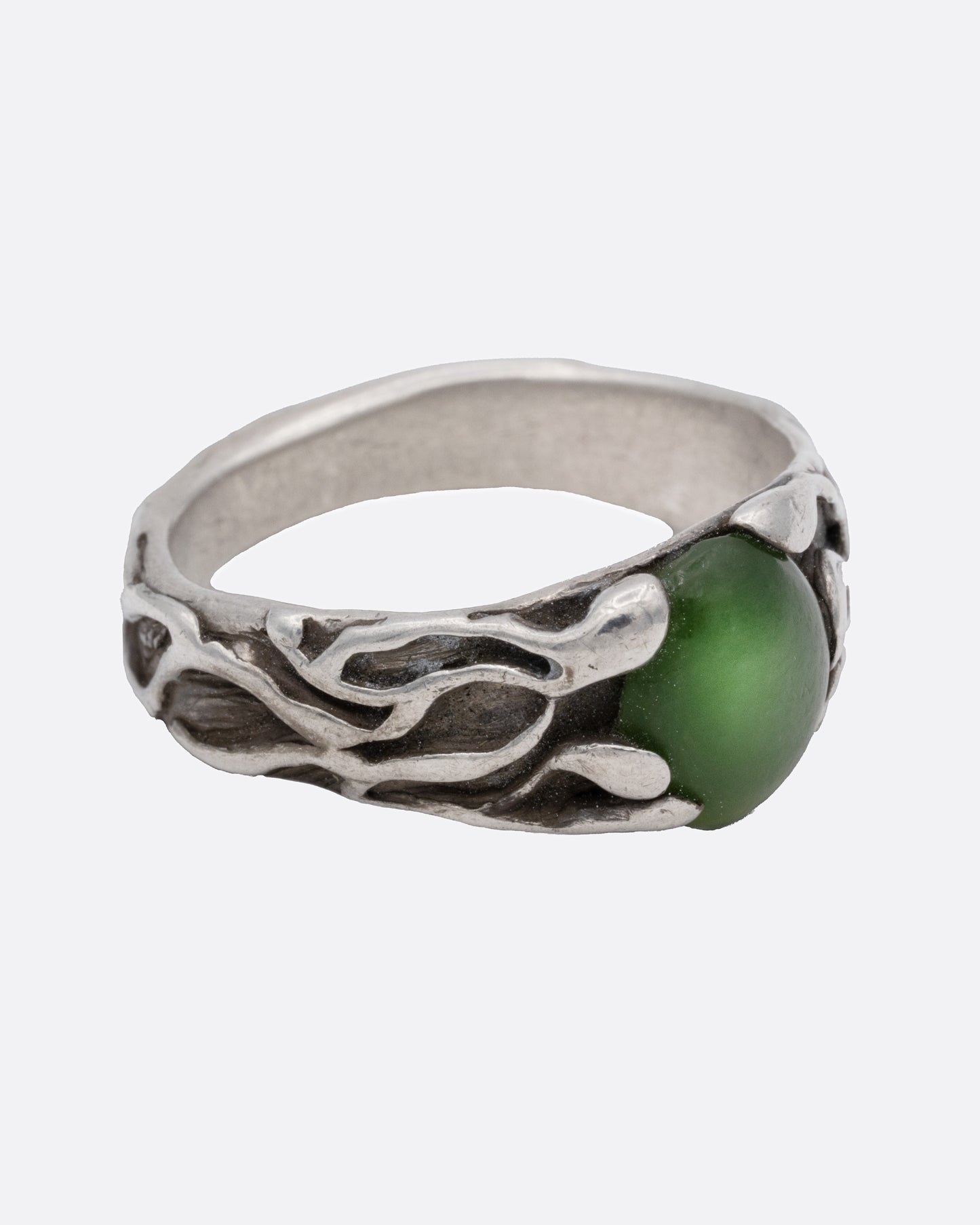 A silver ring with an oval jade at the center, shown from the side.