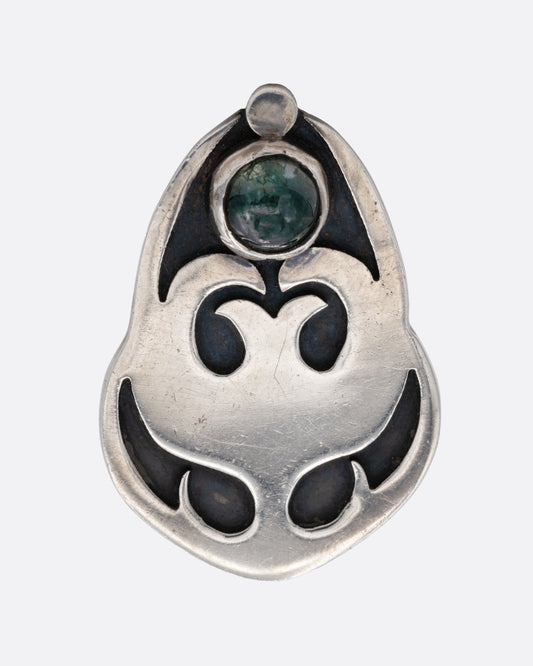 A large silver ring with a curling design and green quartz. Shown from the front.