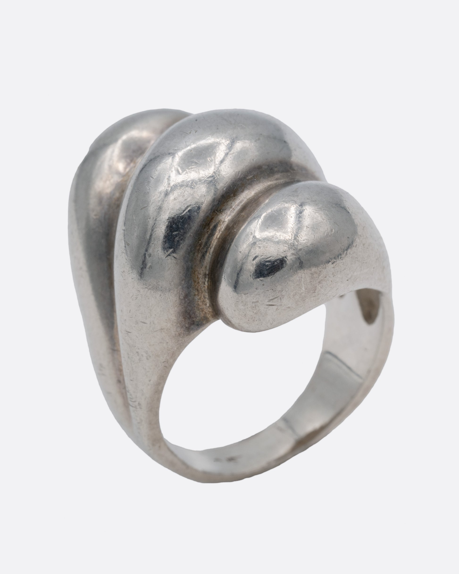 A silver ring with three domed tiers, shown from the side standing up.