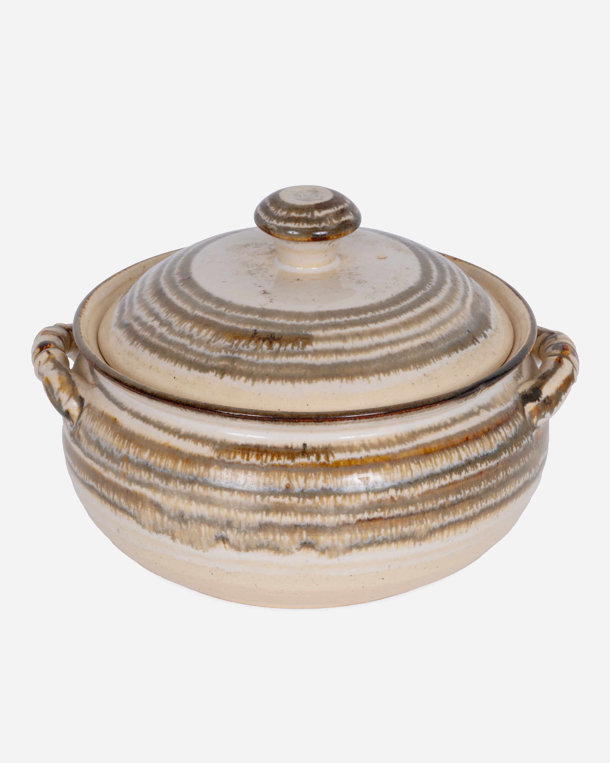 A beige striped casserole dish with dual handles and a domed lid, shown from the front.