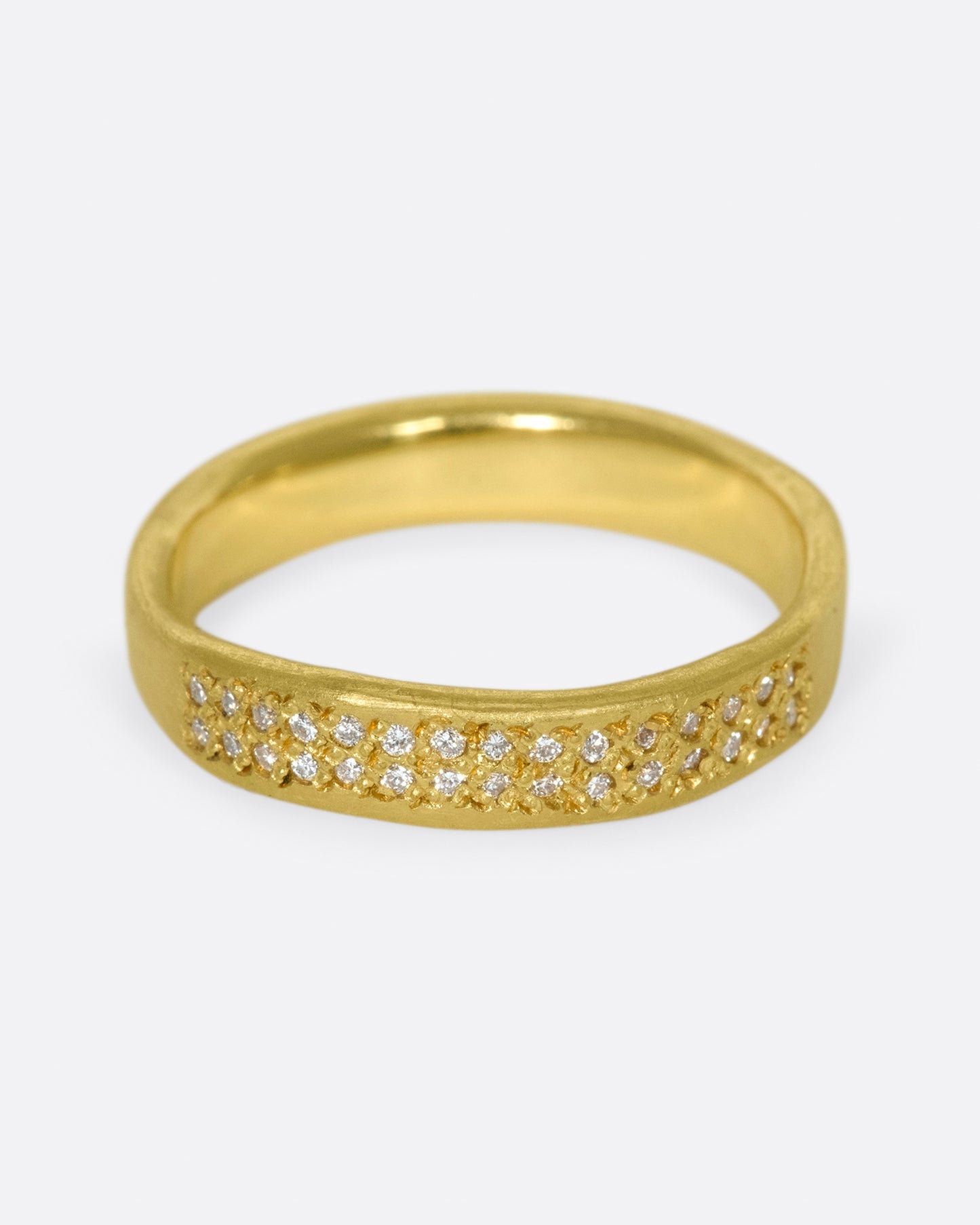 A hand-formed, brushed gold band with two rows of diamonds along half of it.