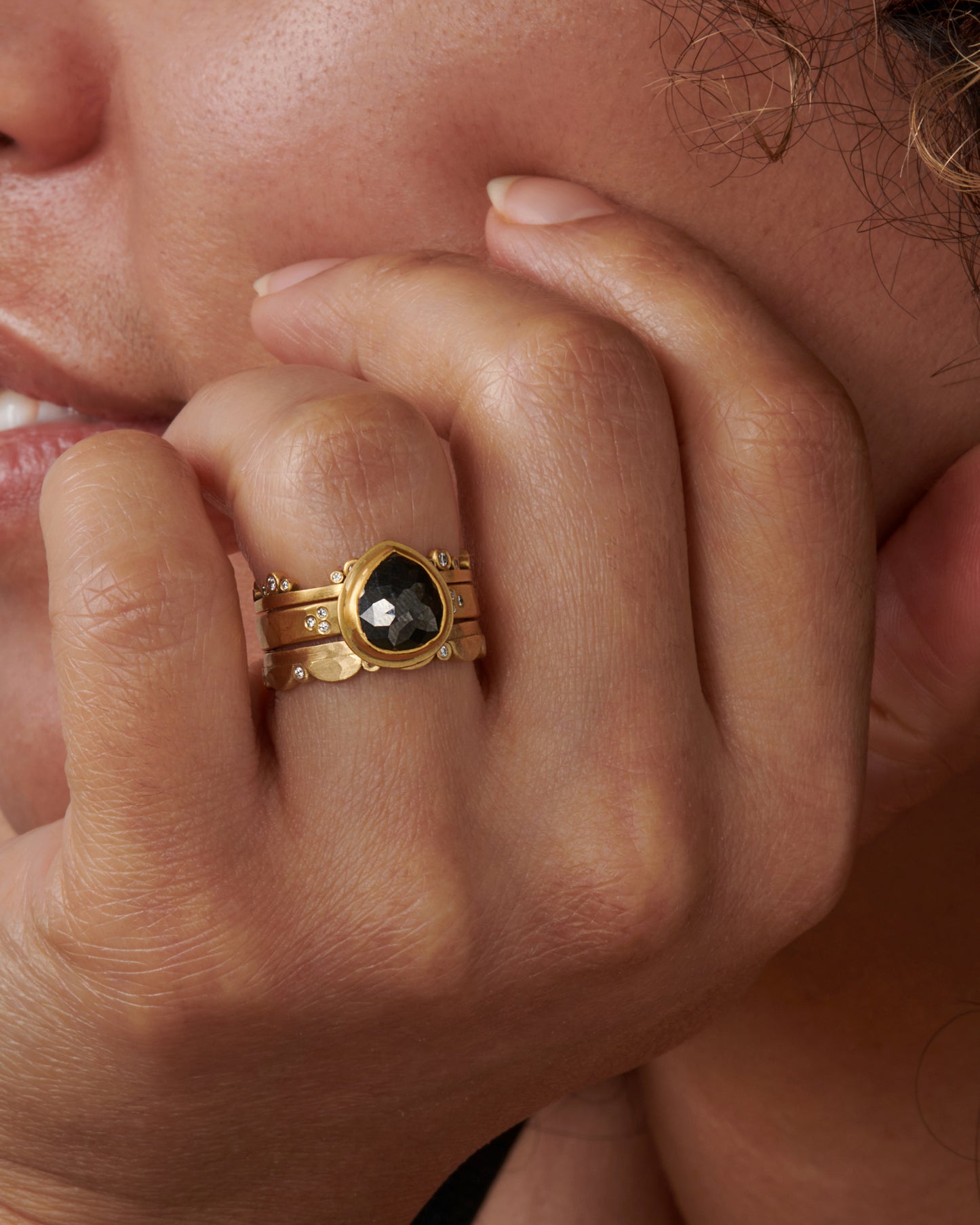 A delightful&nbsp;ring&nbsp;that's scalloped on one side, punctuated by sparkling inset diamonds, shown stacked with other rings.