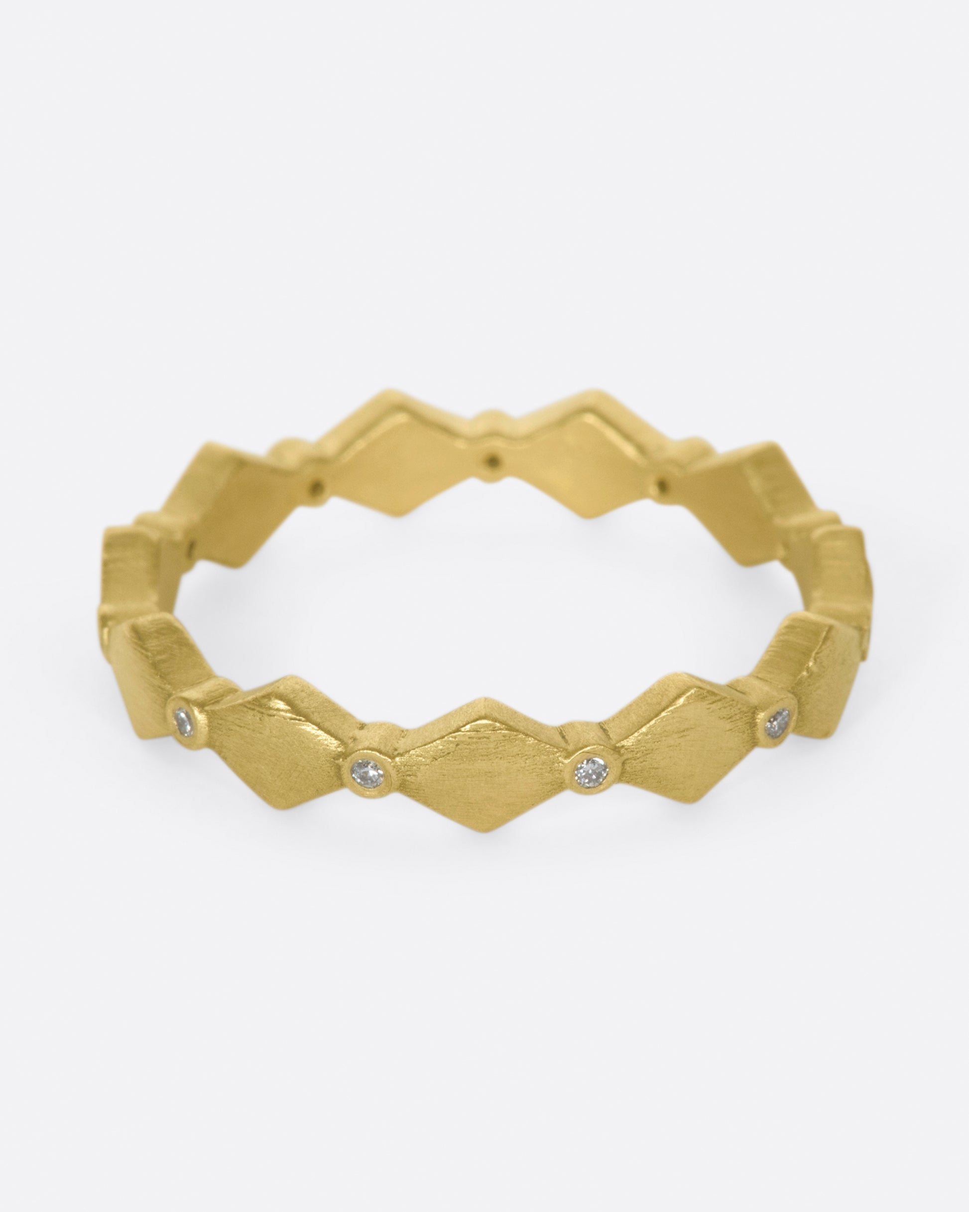 A geometric band with alternating round diamonds and matte gold shapes.