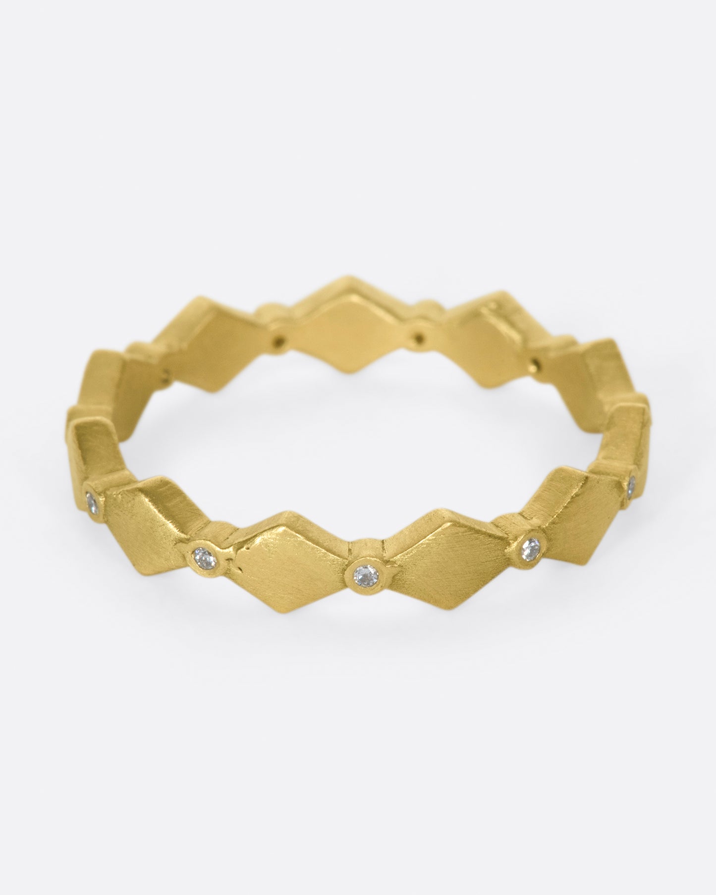 A geometric band with alternating round diamonds and matte gold shapes.