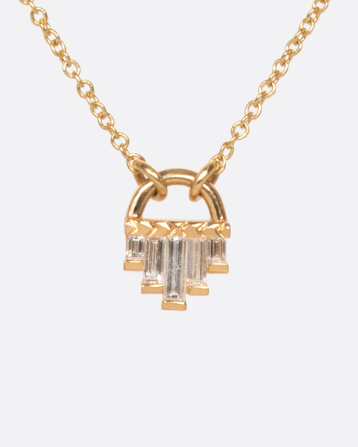 A curved gold pendant necklace with five diamond baguettes.
