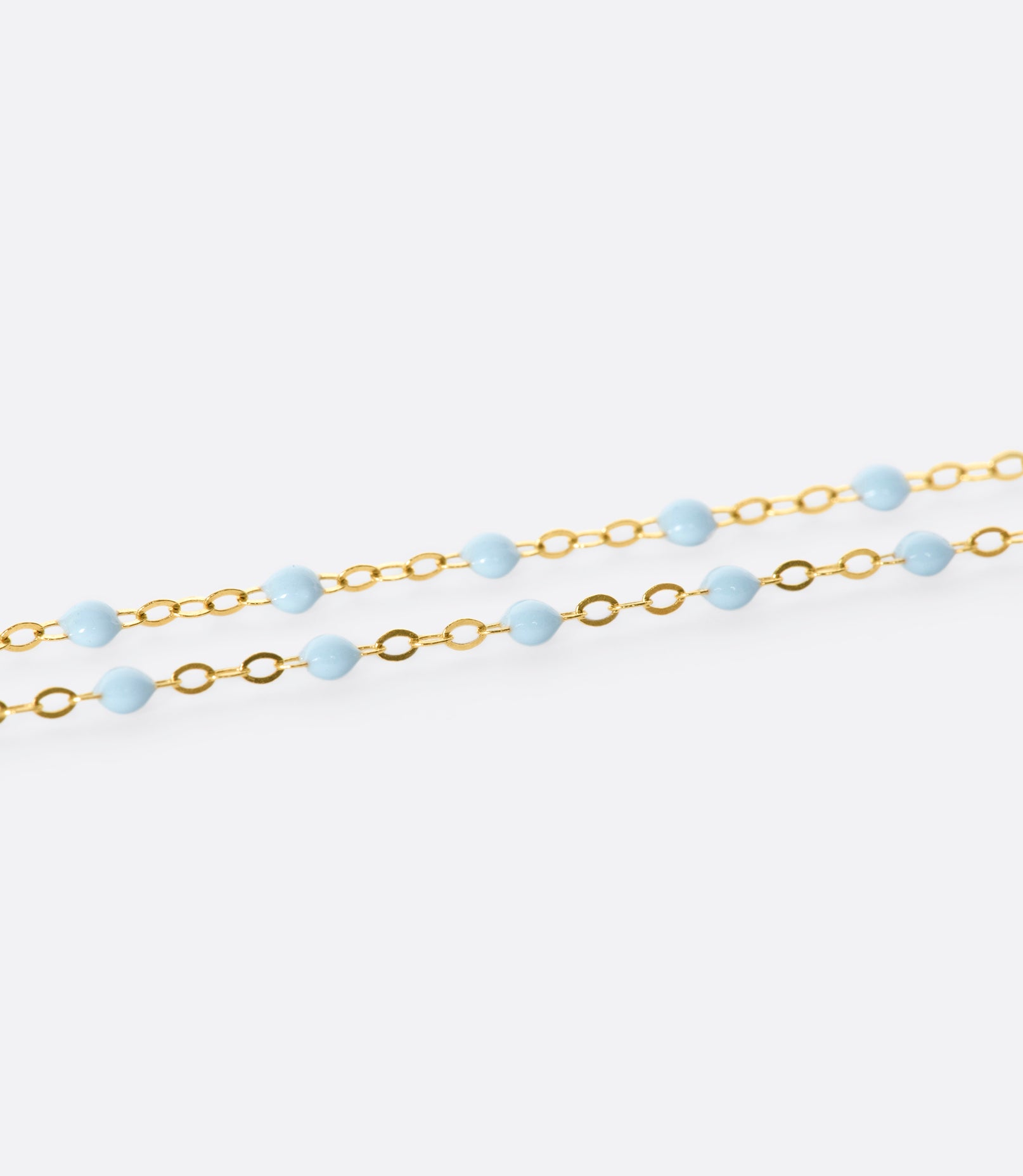 A thin yellow gold chain necklace with resin beads. Each necklace is hand dipped in melted resin to create the beaded effect. 