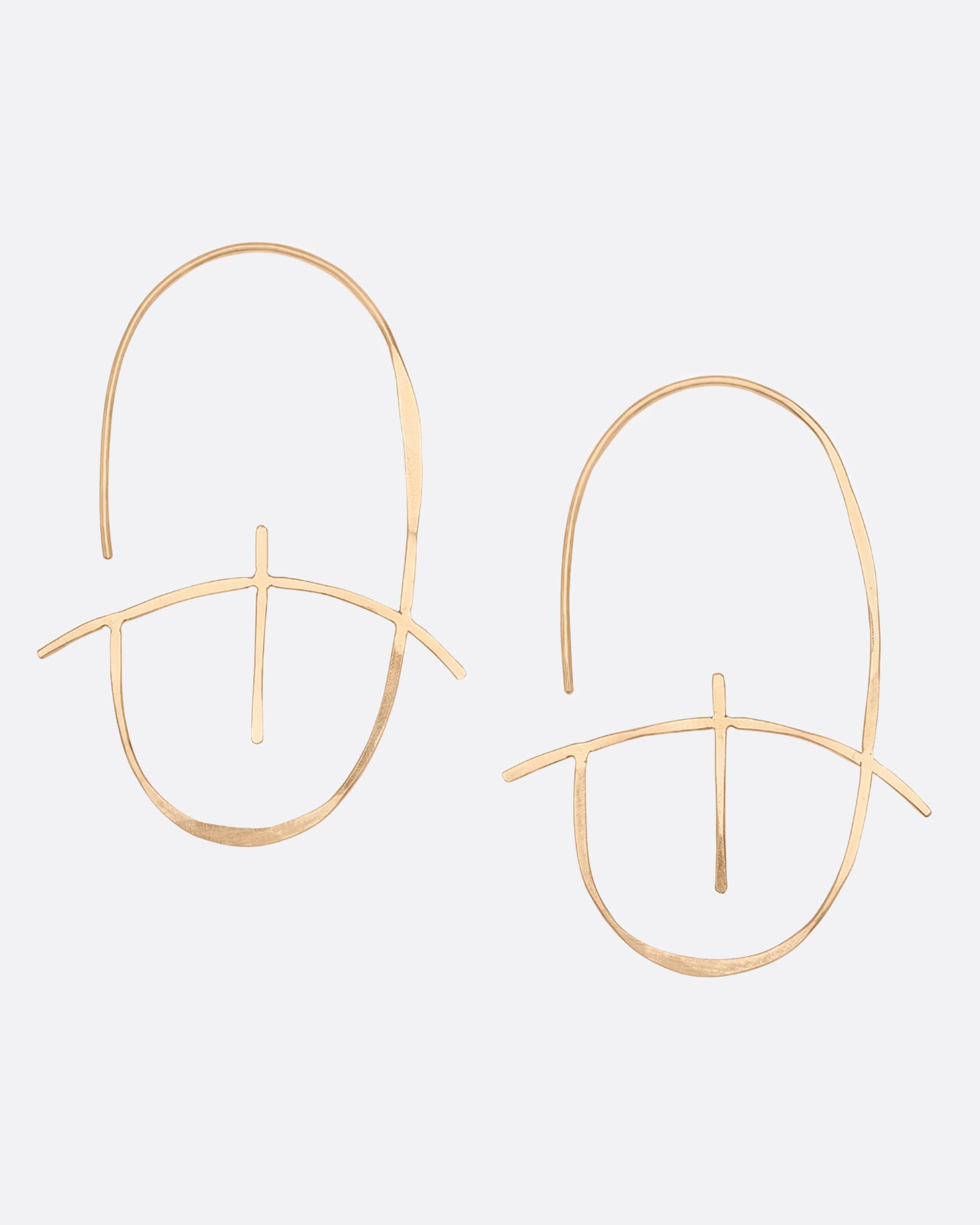 A geometric earring made of thin yellow gold with a hammered finish